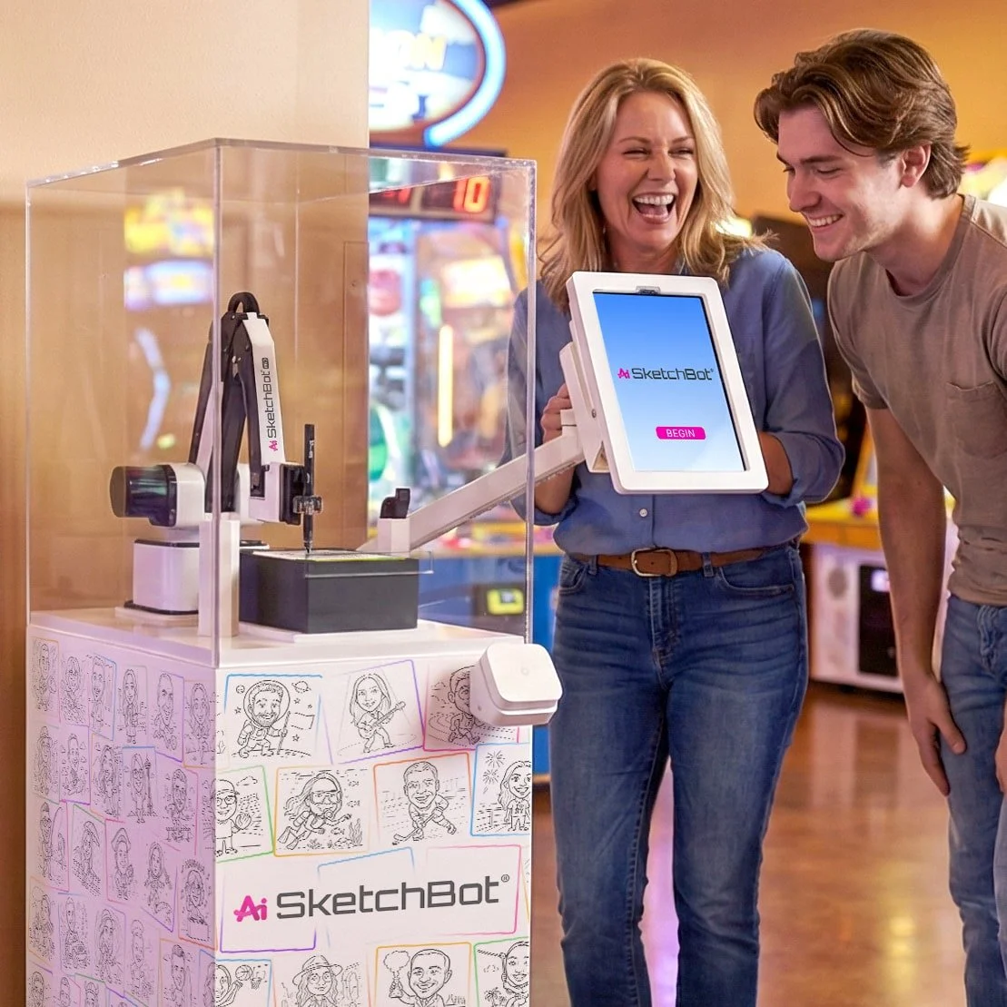 Two guests watching in excitement as SketchBot Pro draws their portraits