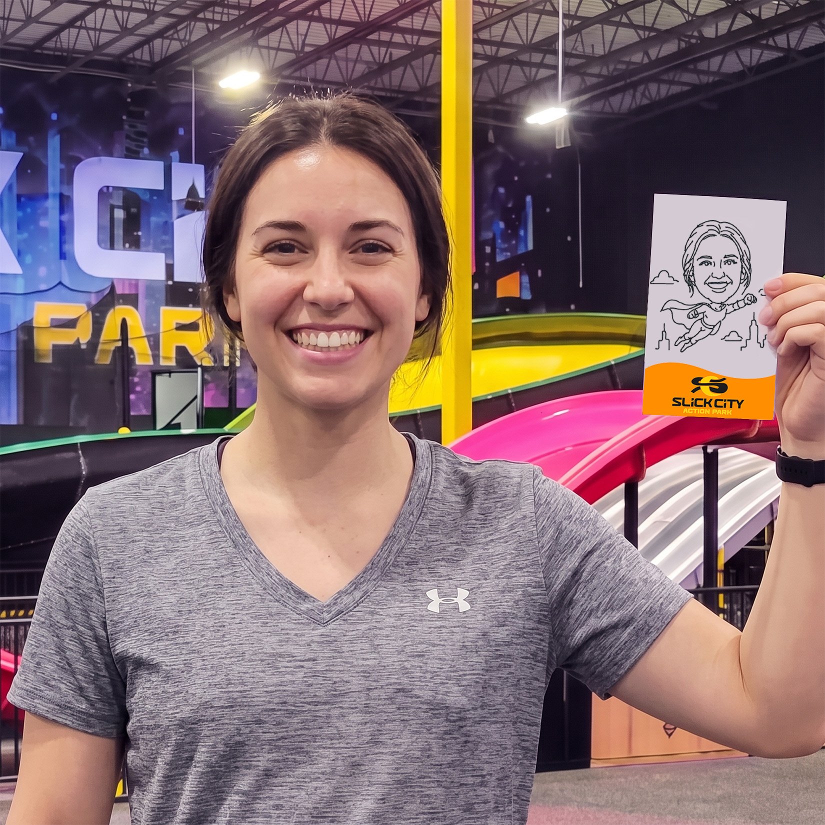 A woman holding up her robotic drawn sketch at Slick City