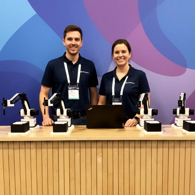 Friendly staff posing with the SketchBots on a table