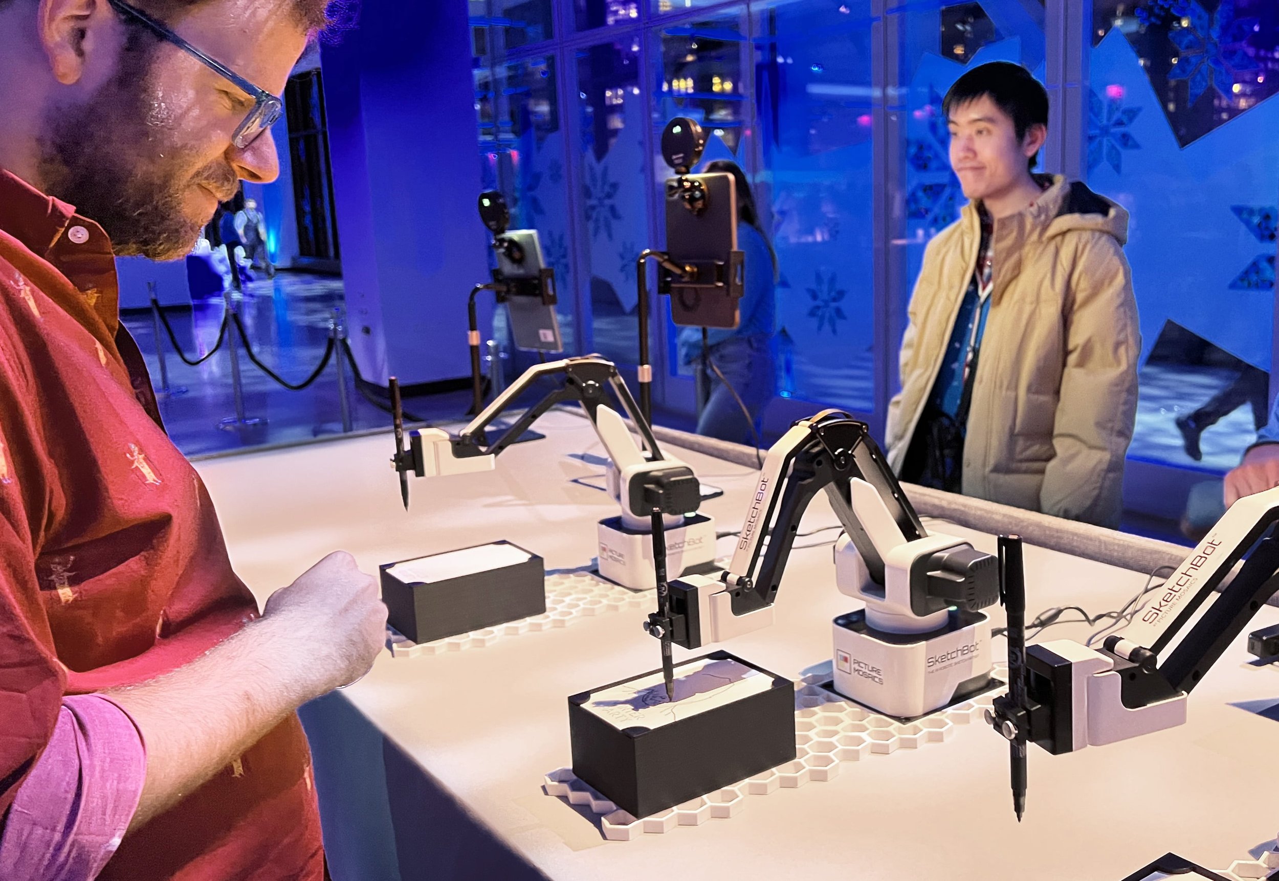 Guest watching as the SketchBot draws their portrait