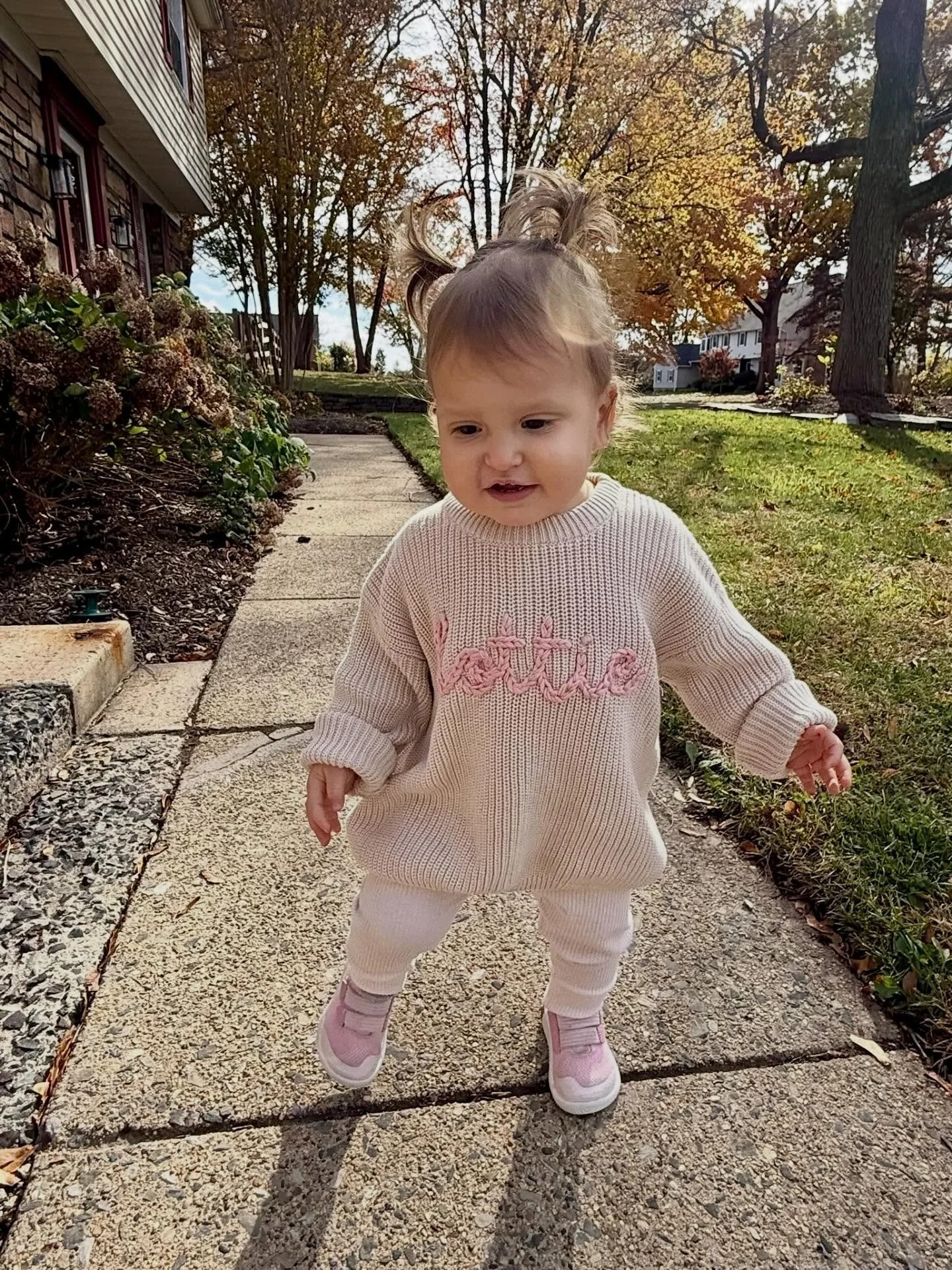 Hand embroidered chain stitch style lettering in Rose, on a chunky style children&rsquo;s sweater in the color Sand.