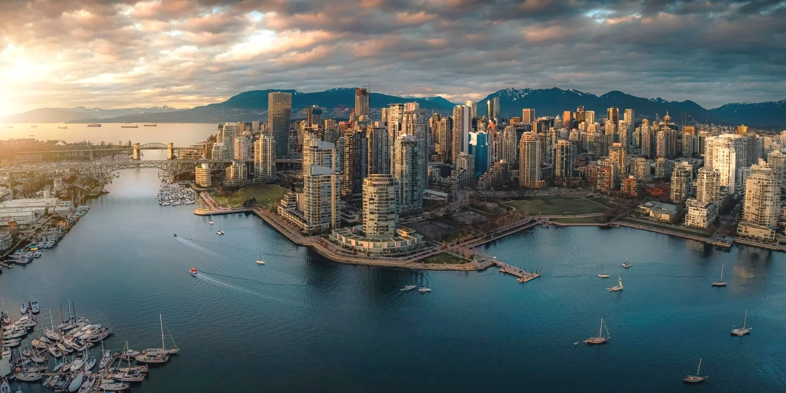 Vancouver skyline glowing at sunset, where the ocean meets the mountains in a breathtaking city view.