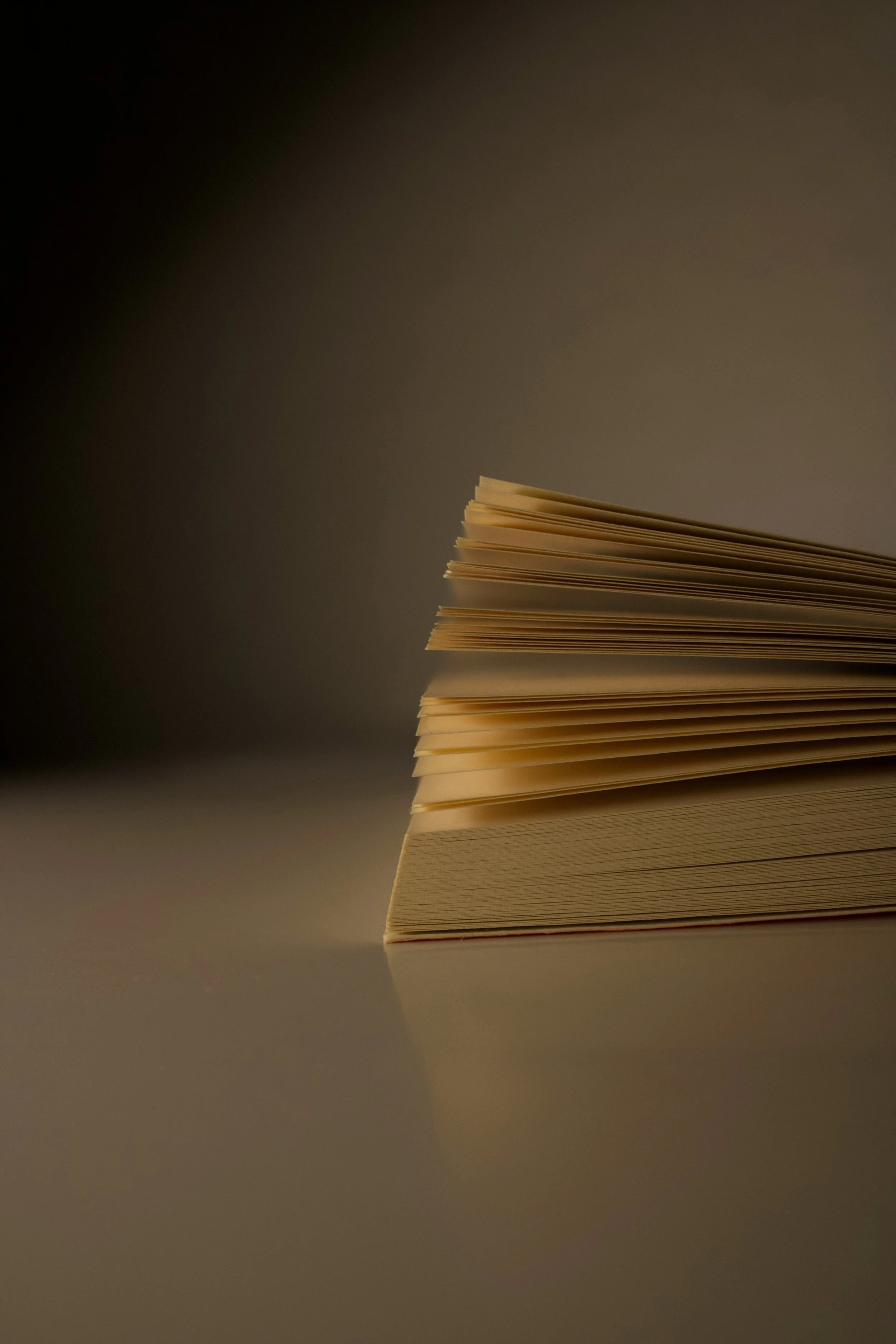 Close-up of a neatly stacked pile of paper sheets on a surface, with a gradient background.