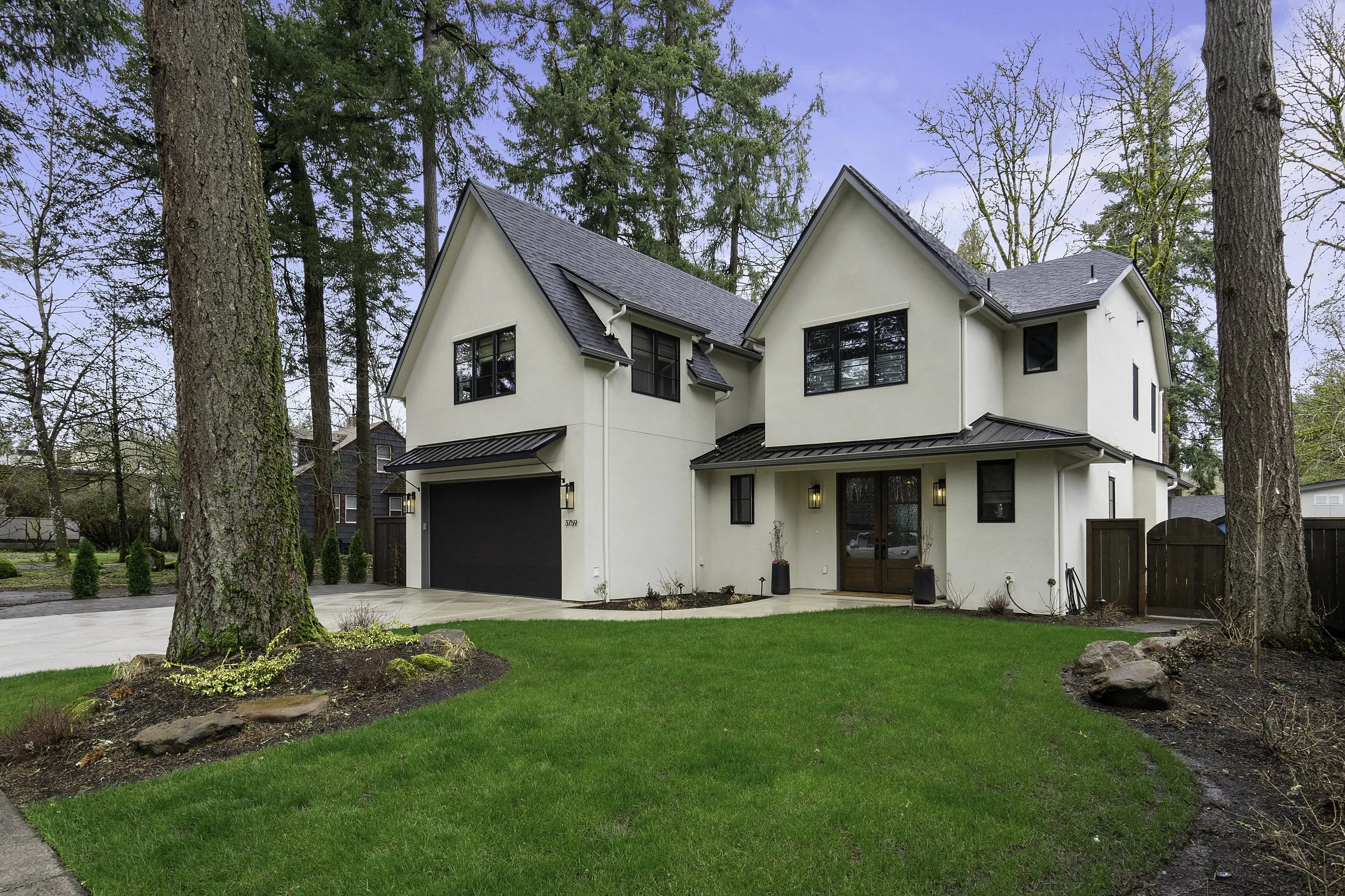 Modern white two-story house with dark roof and large black window frames in the Willamette Valley.