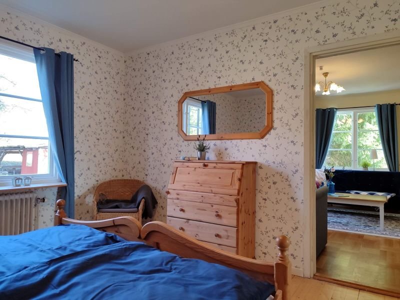 Schweden-Auszeit: Schlafzimmer in Blautönen und Holz mit geblümter Tapete 