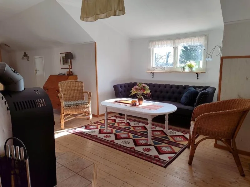 SchwedenAuszeit: Wohnzimmerecke mit Korbstühlen, Sofa und Kamin