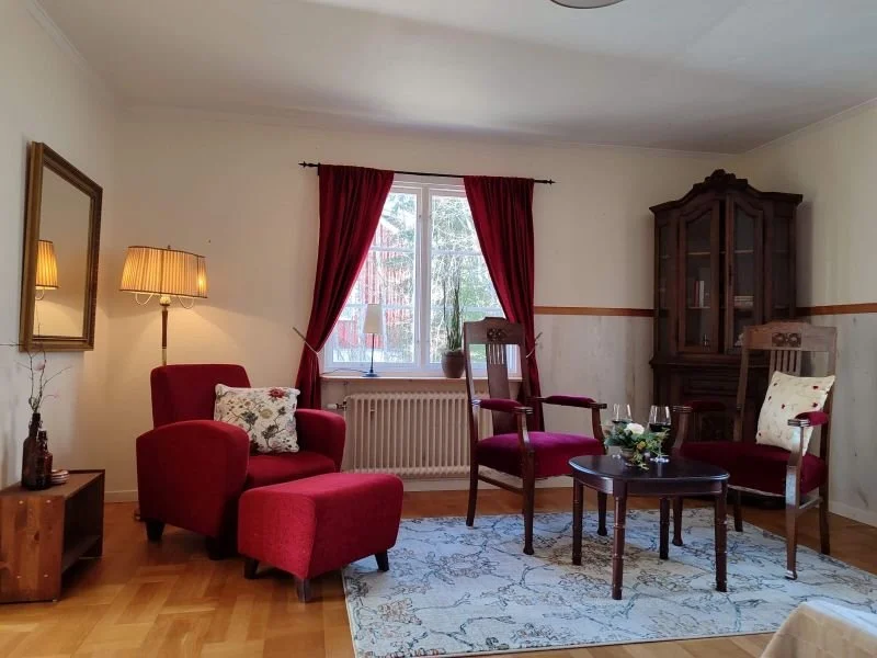 Schweden-Auszeit: Wohnzimmer im royalen Stil, mit rotem Stoff und dunklem Holz