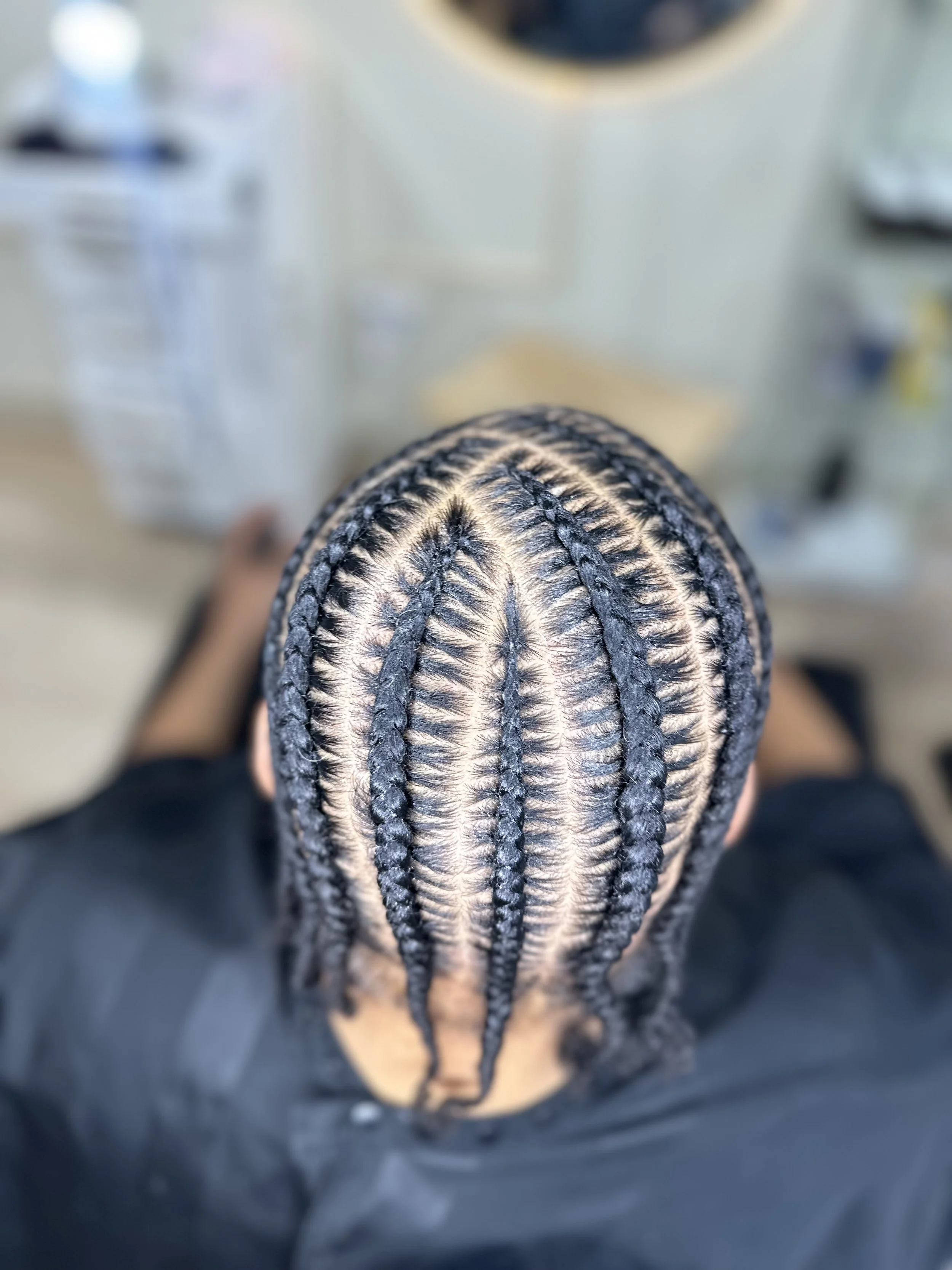 Men’s stitch braids with detailed curved scalp design and clean finishing