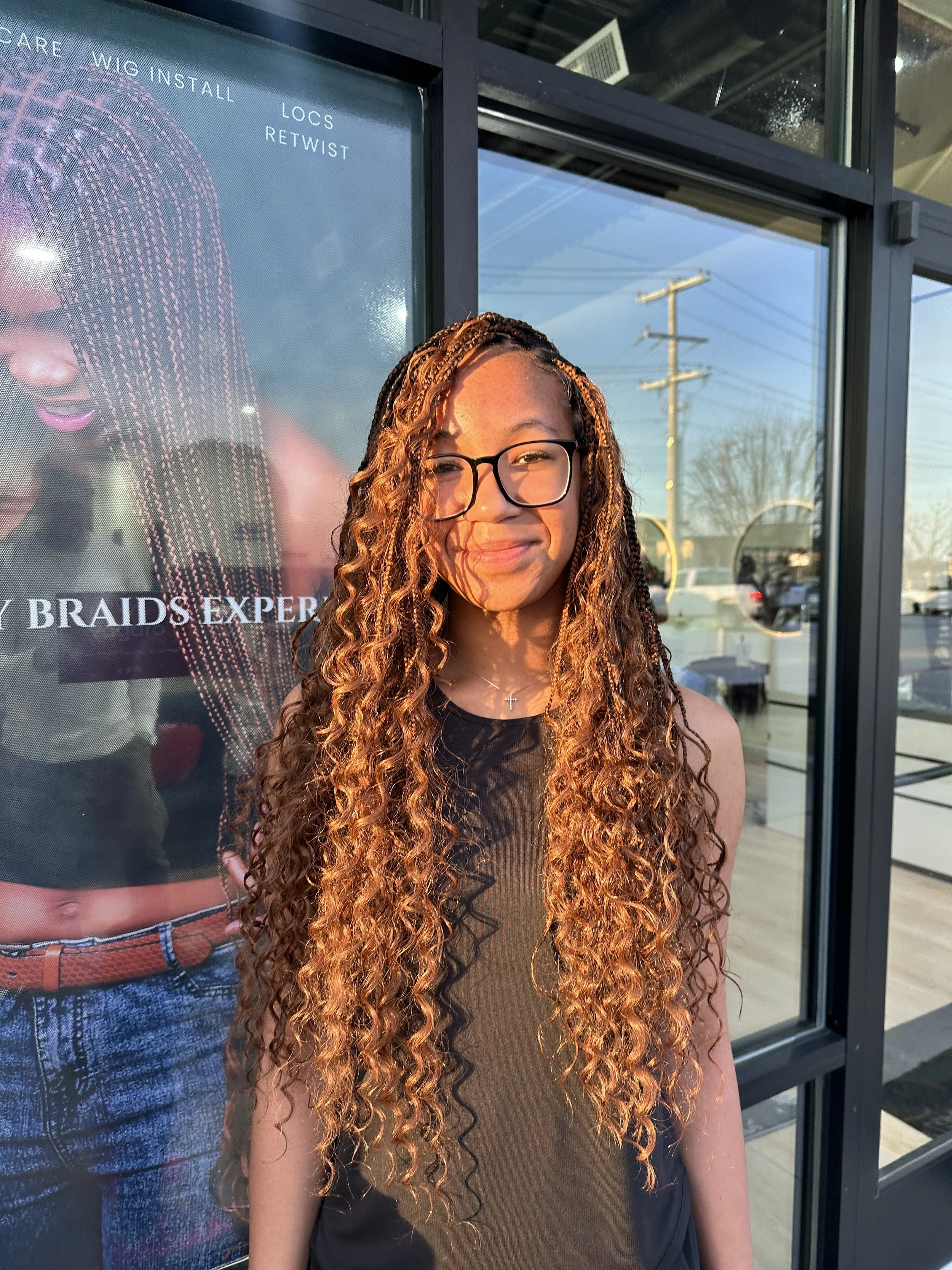 Girl wearing long copper-brown boho braids with curly human hair at Legacy Braids in McKinney, TX