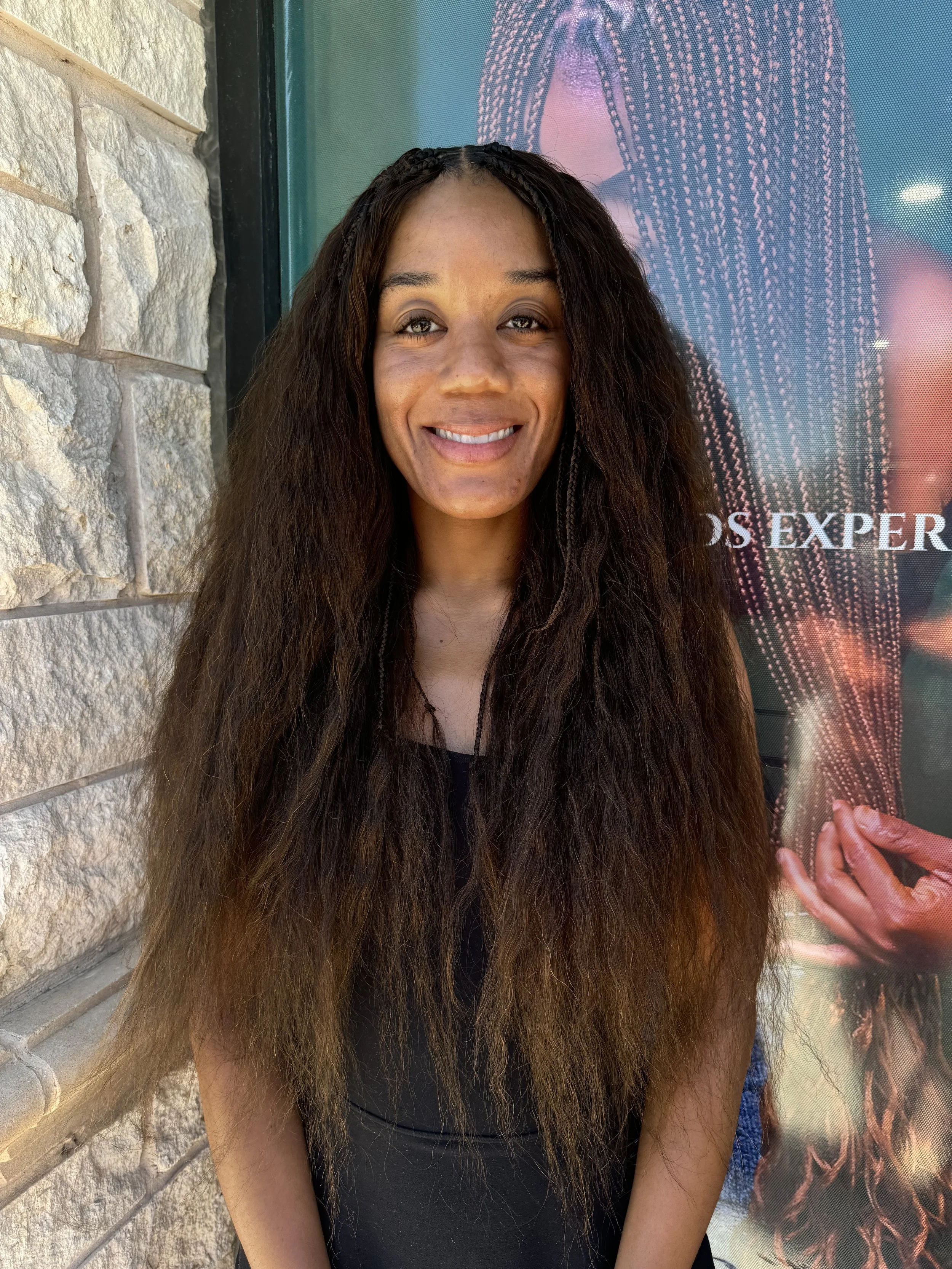 Woman wearing long brown boho braids with soft wavy human hair at Legacy Braids in McKinney, TX