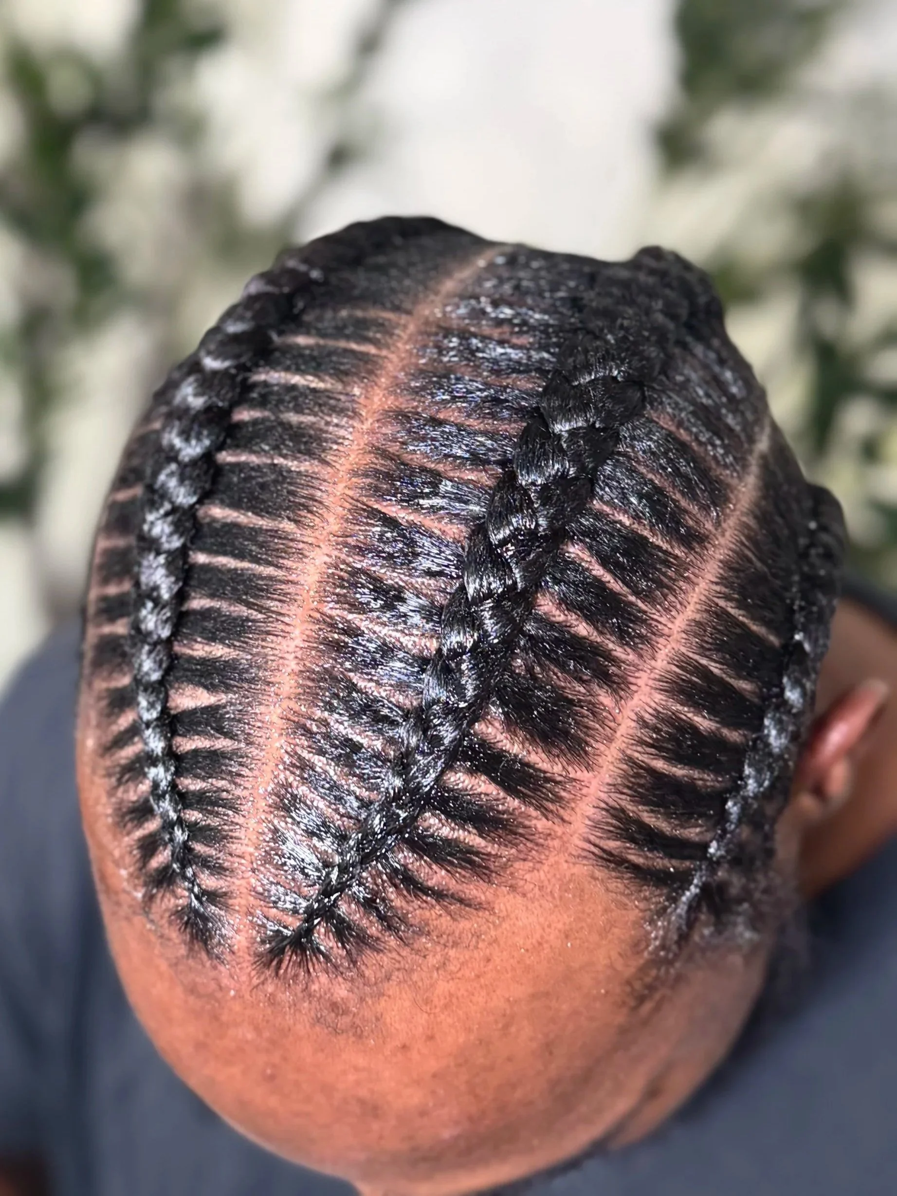Men’s four stitch braids with precise parting and a polished finish