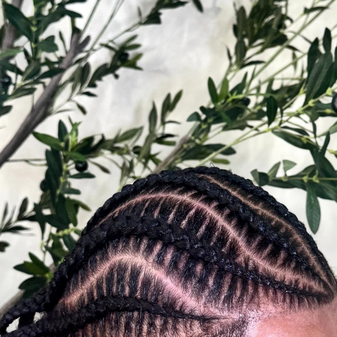 Men’s stitch braids with curved scalp patterns and precise parting