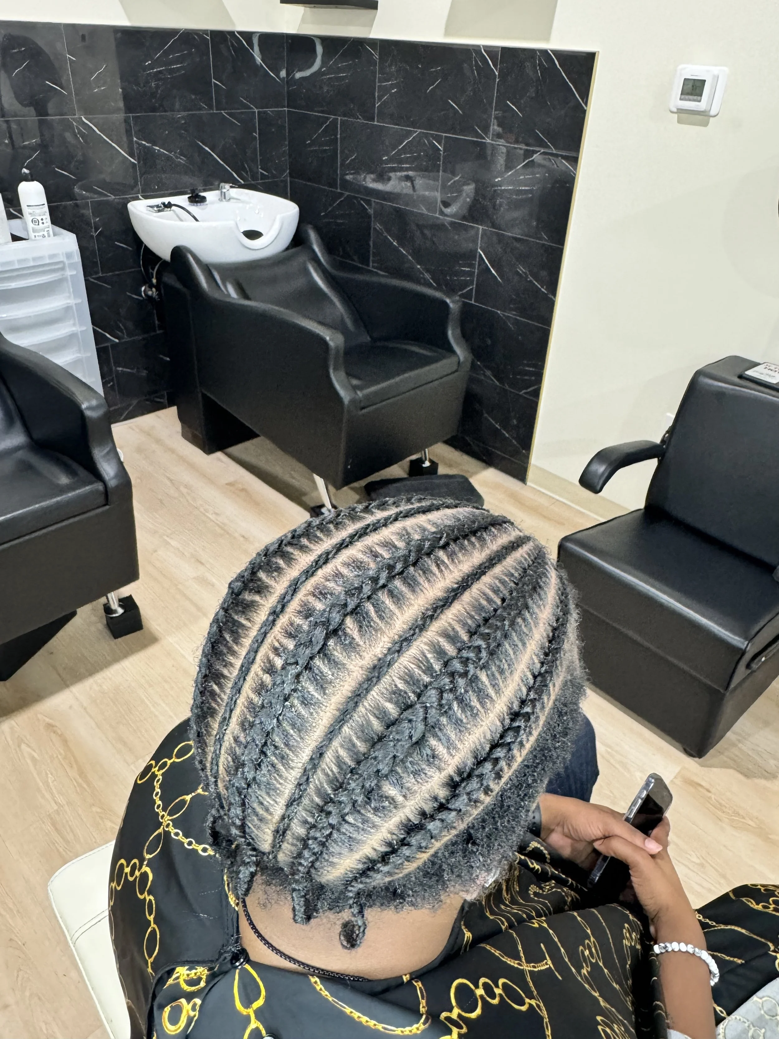 Men’s stitch braids with alternating size curved sections and clean parting