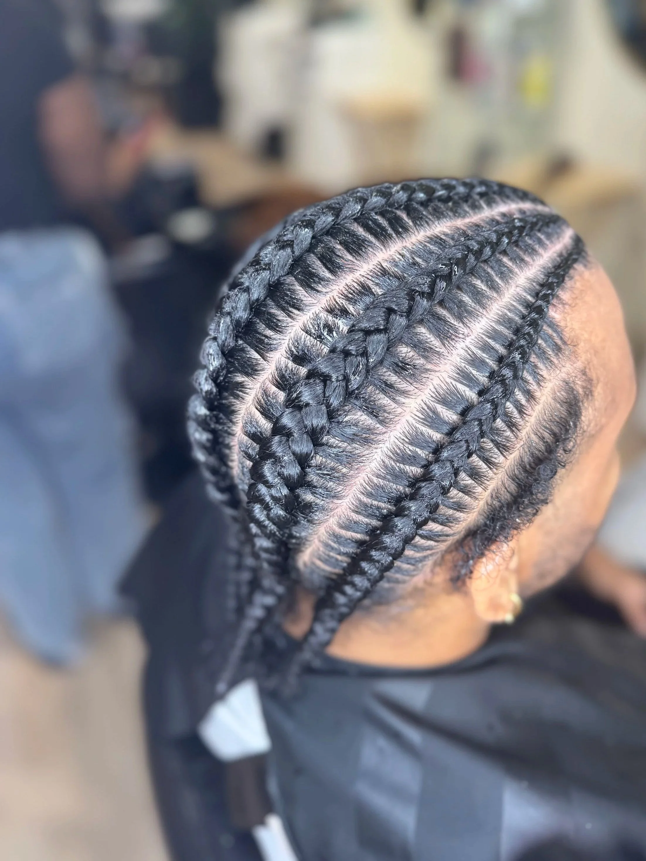 Men’s stitch braids with custom scalp design and clean parting at Legacy Braids in McKinney, TX