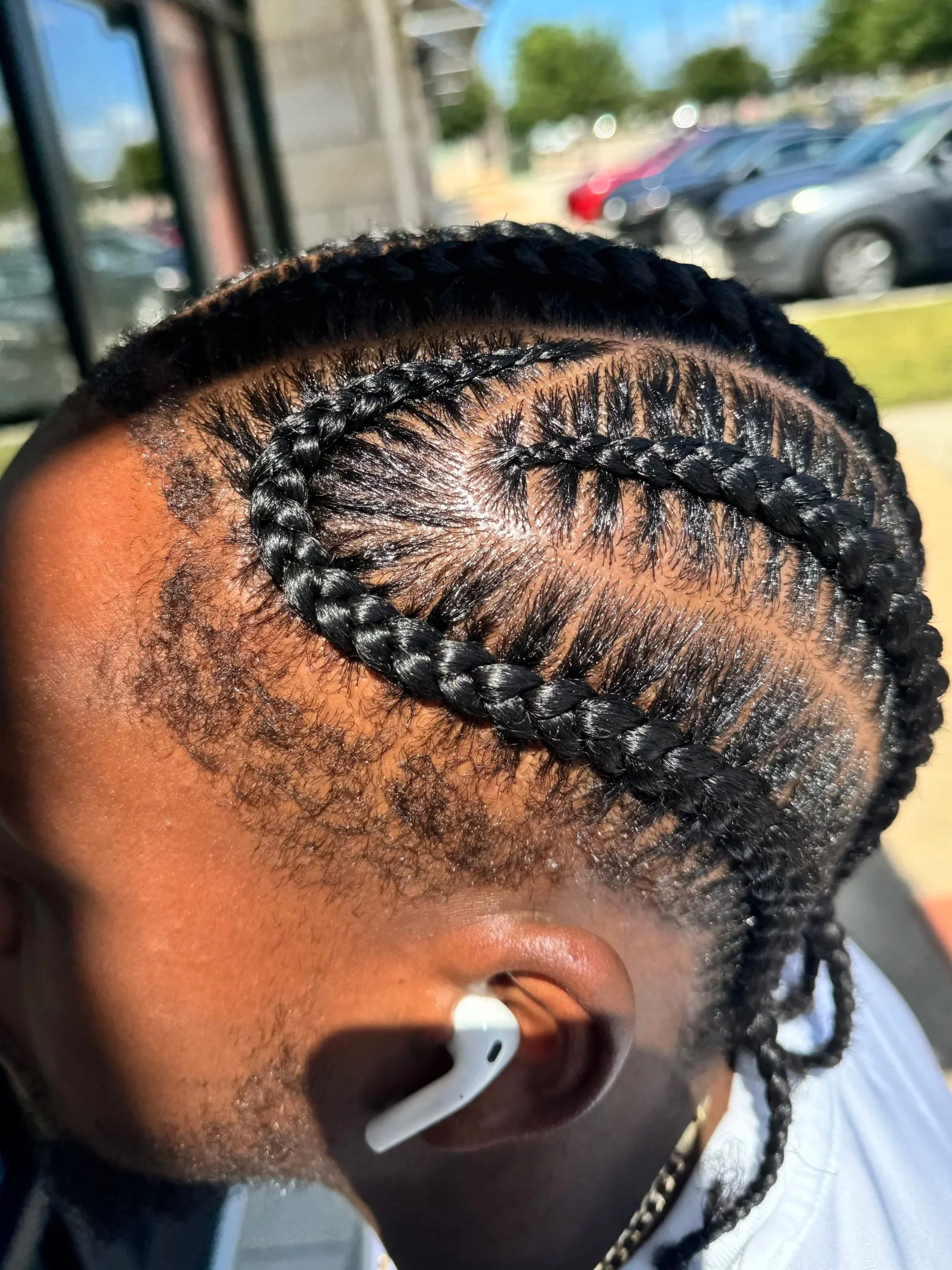 Men’s stitch braids featuring a detailed curved scalp pattern