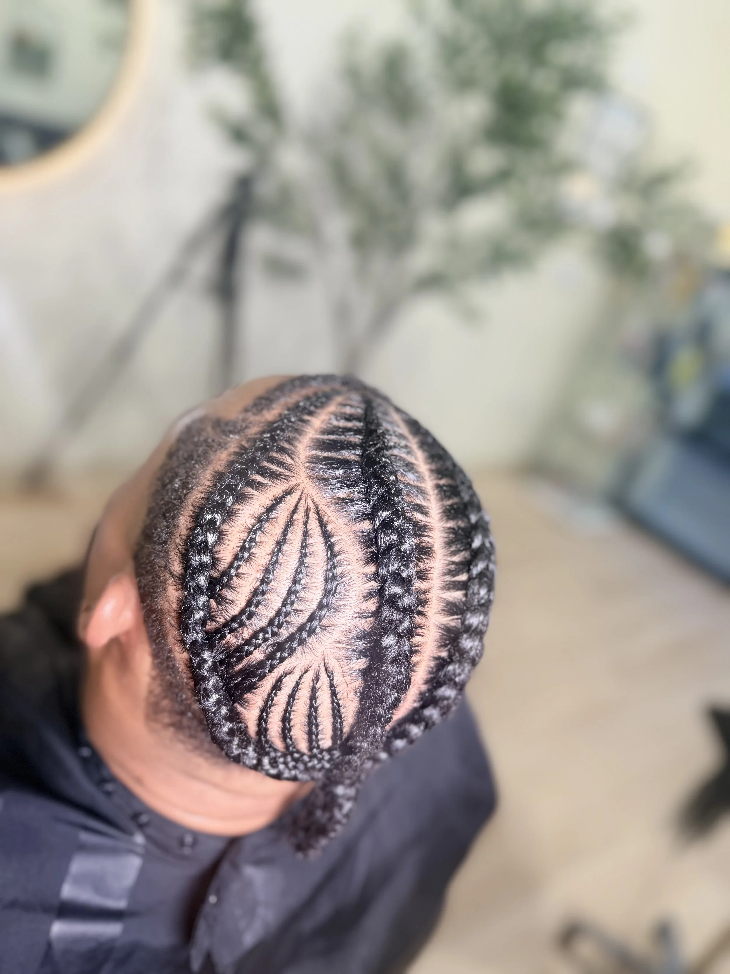 Men’s stitch braids with an intricate leaf-inspired scalp pattern