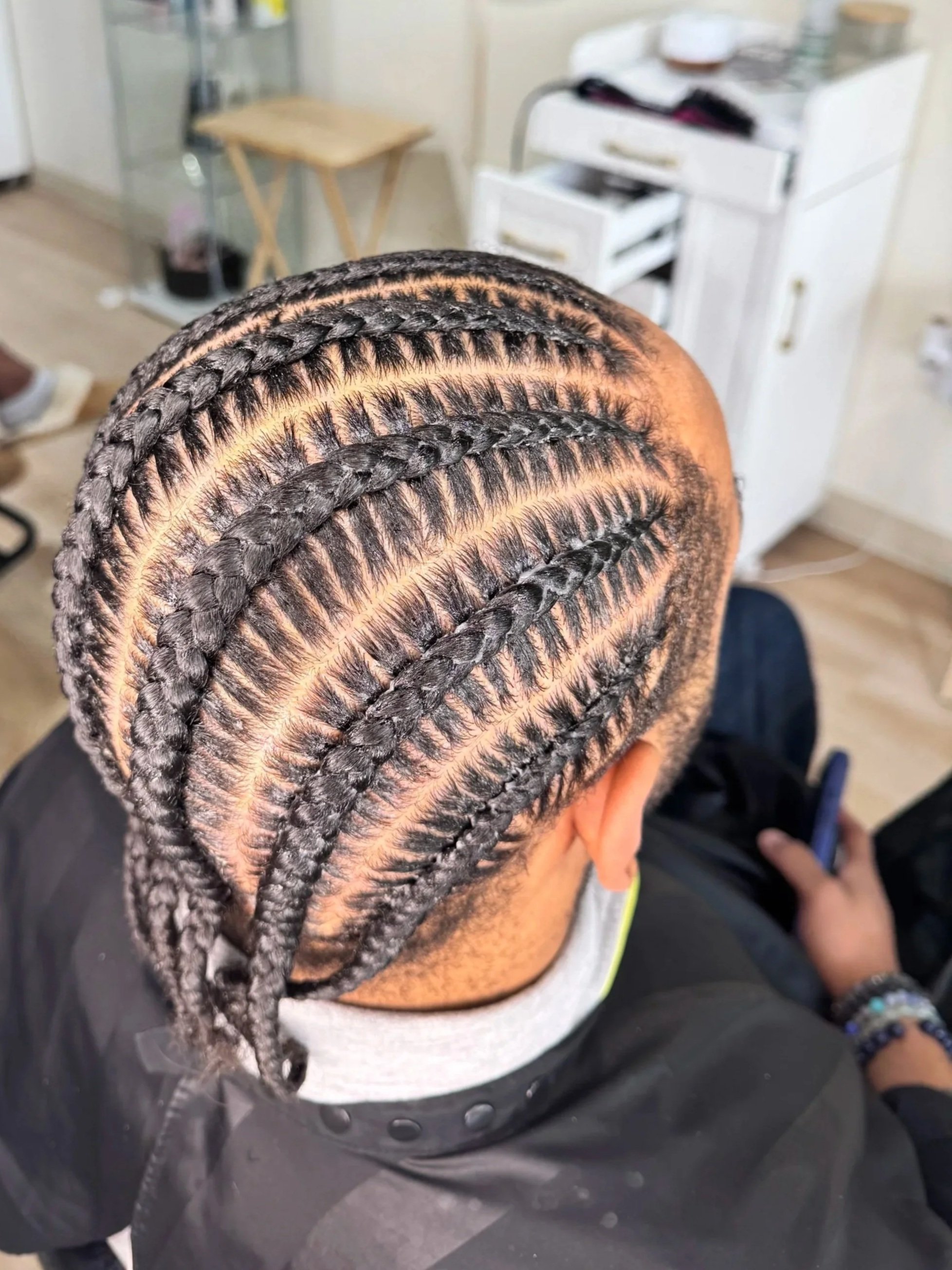 Men’s eight stitch braids with curved parting and defined sections