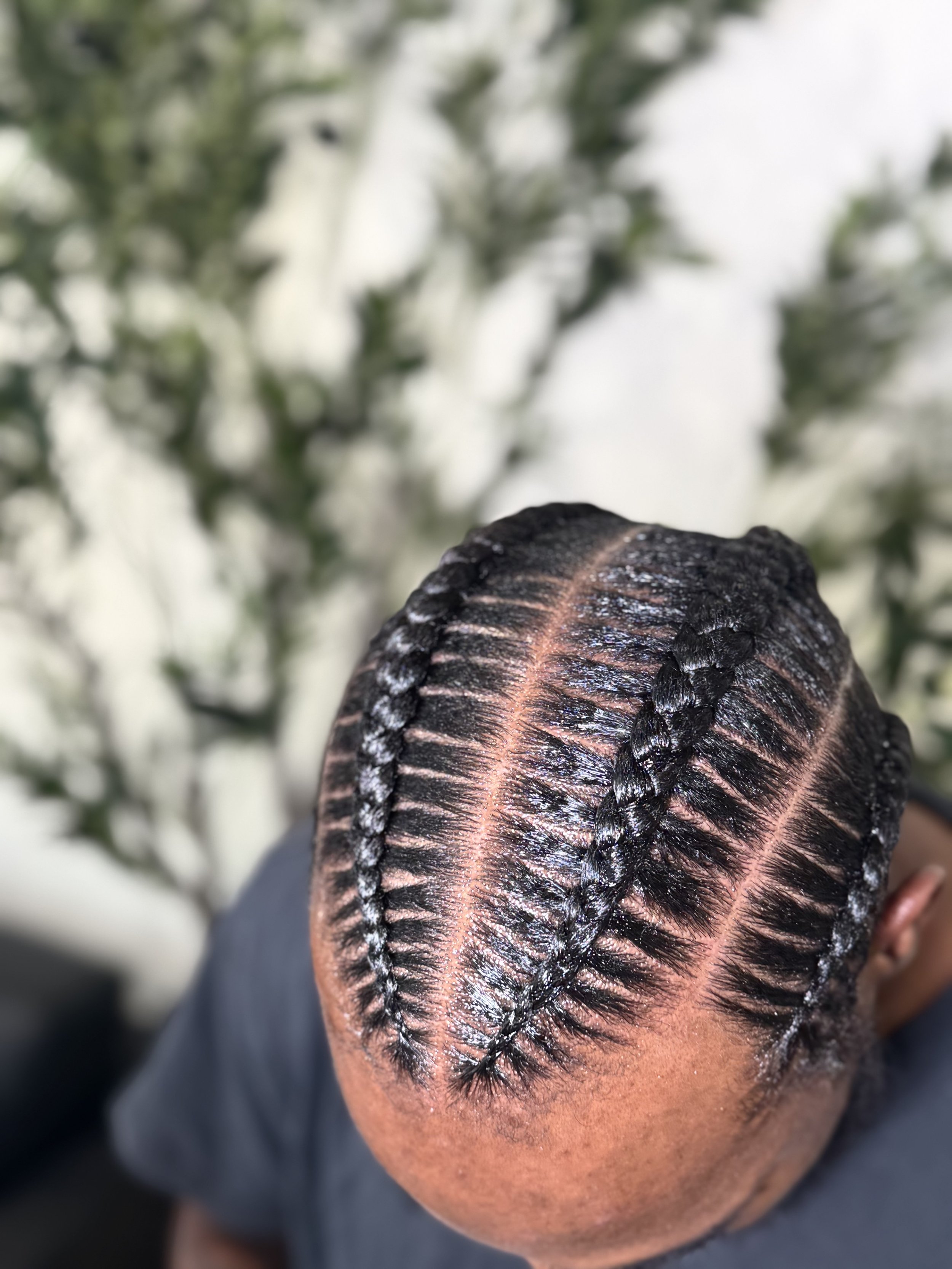 4 Men’s stitch braids with precise curved parting and a polished finish