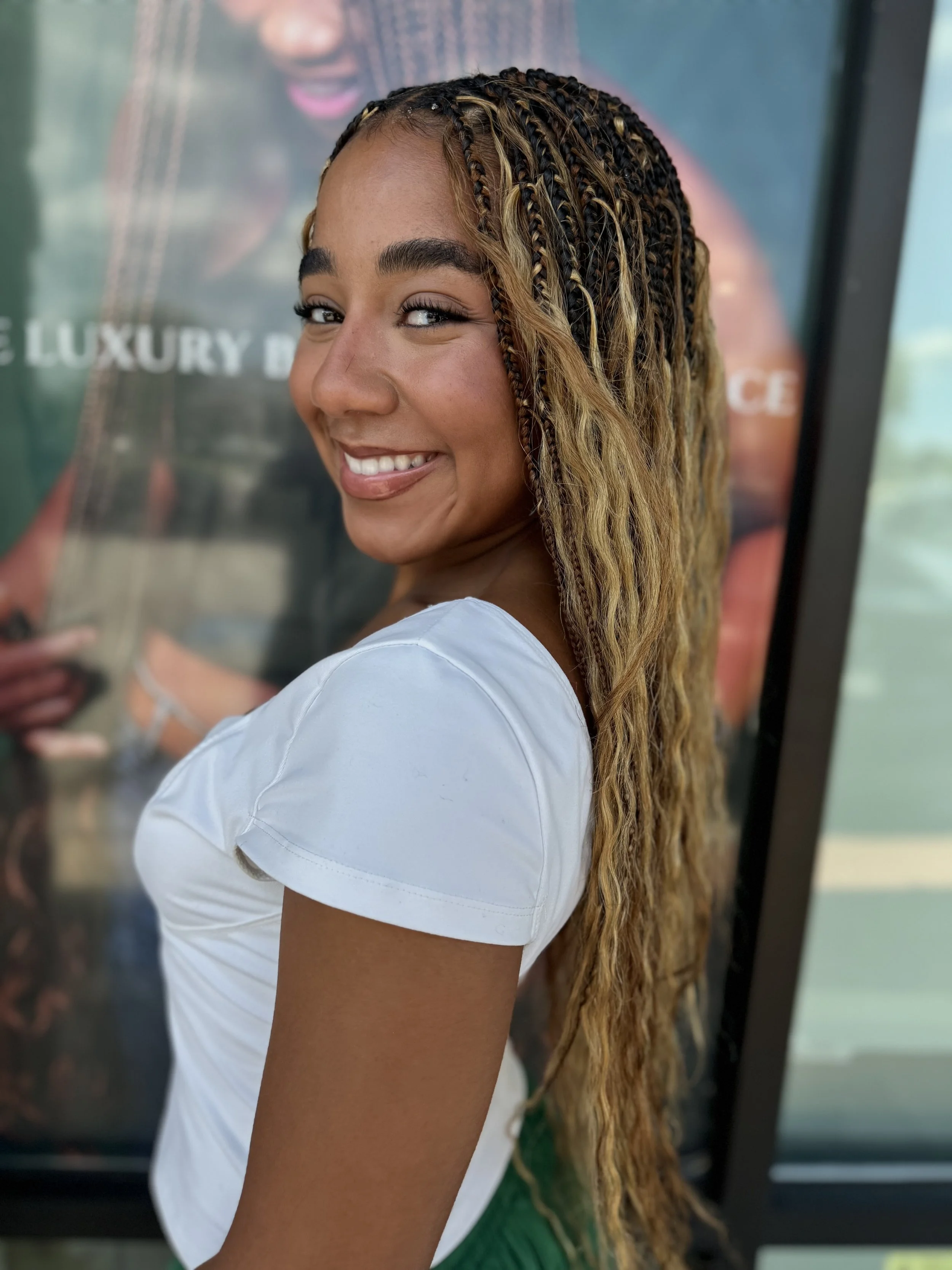 Woman wearing blonde and brown boho braids with long curly human hair at Legacy Braids in McKinney, TX