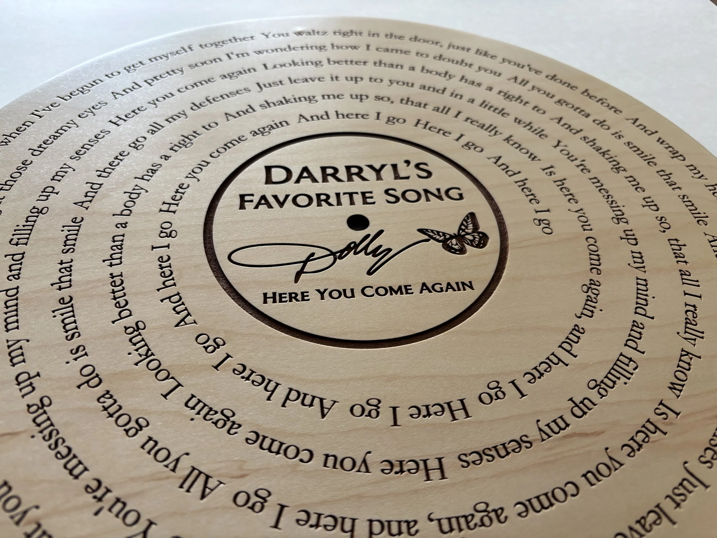 Close up of engraved song lyrics on walnut wood vinyl record