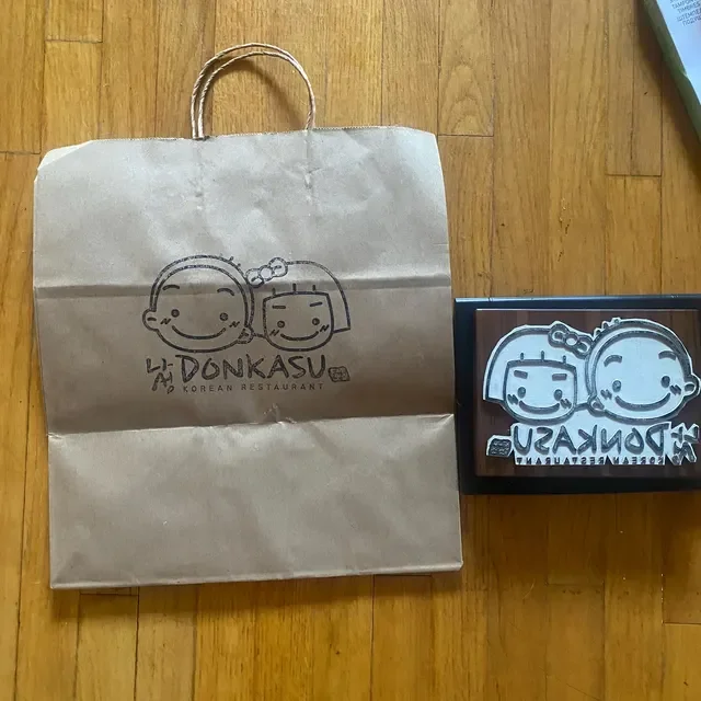 Custom business logo stamp used on kraft paper shopping bag for branded retail packaging