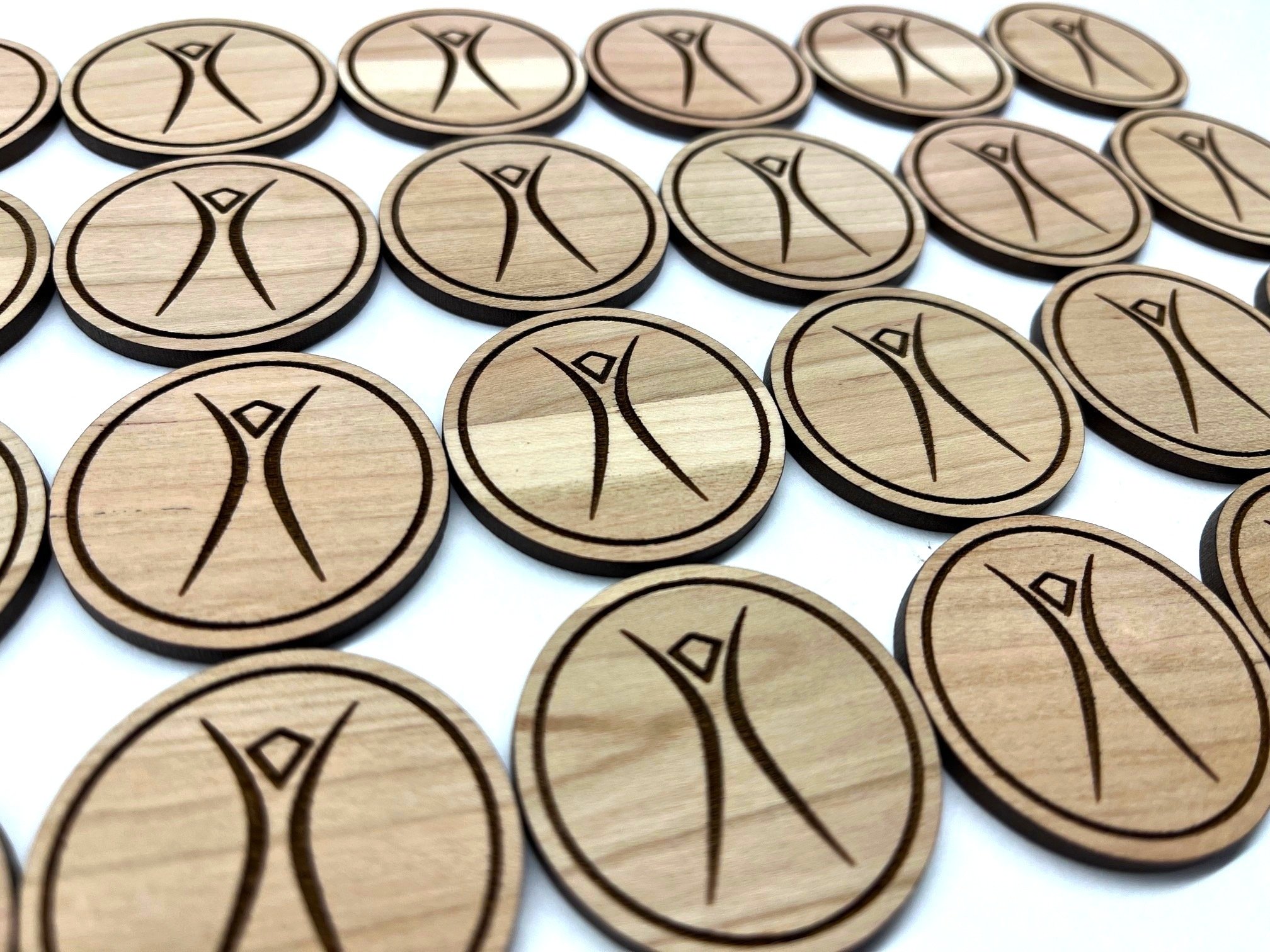 Custom engraved wood coins with logos or designs – ideal for branding, events, and wedding favors. Made from walnut, cherry, or maple.