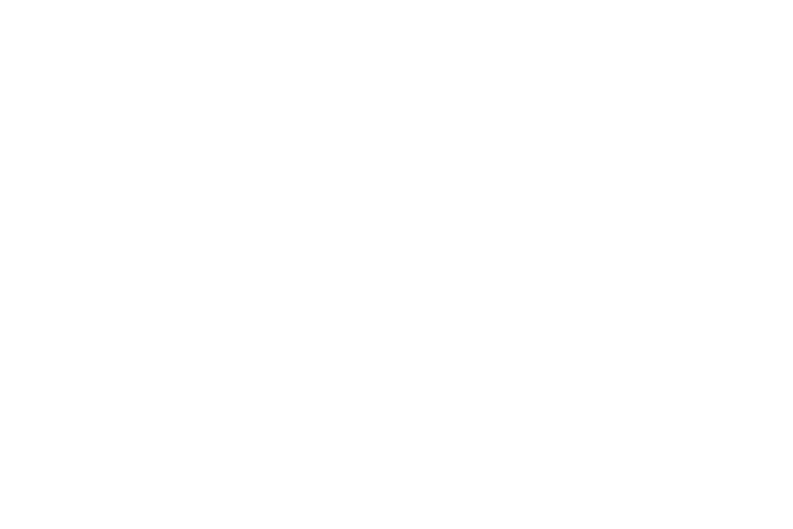 A black and white image of a motorcycle parked on a street with a building in the background.