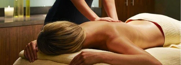 A woman getting a back massage in a spa room.