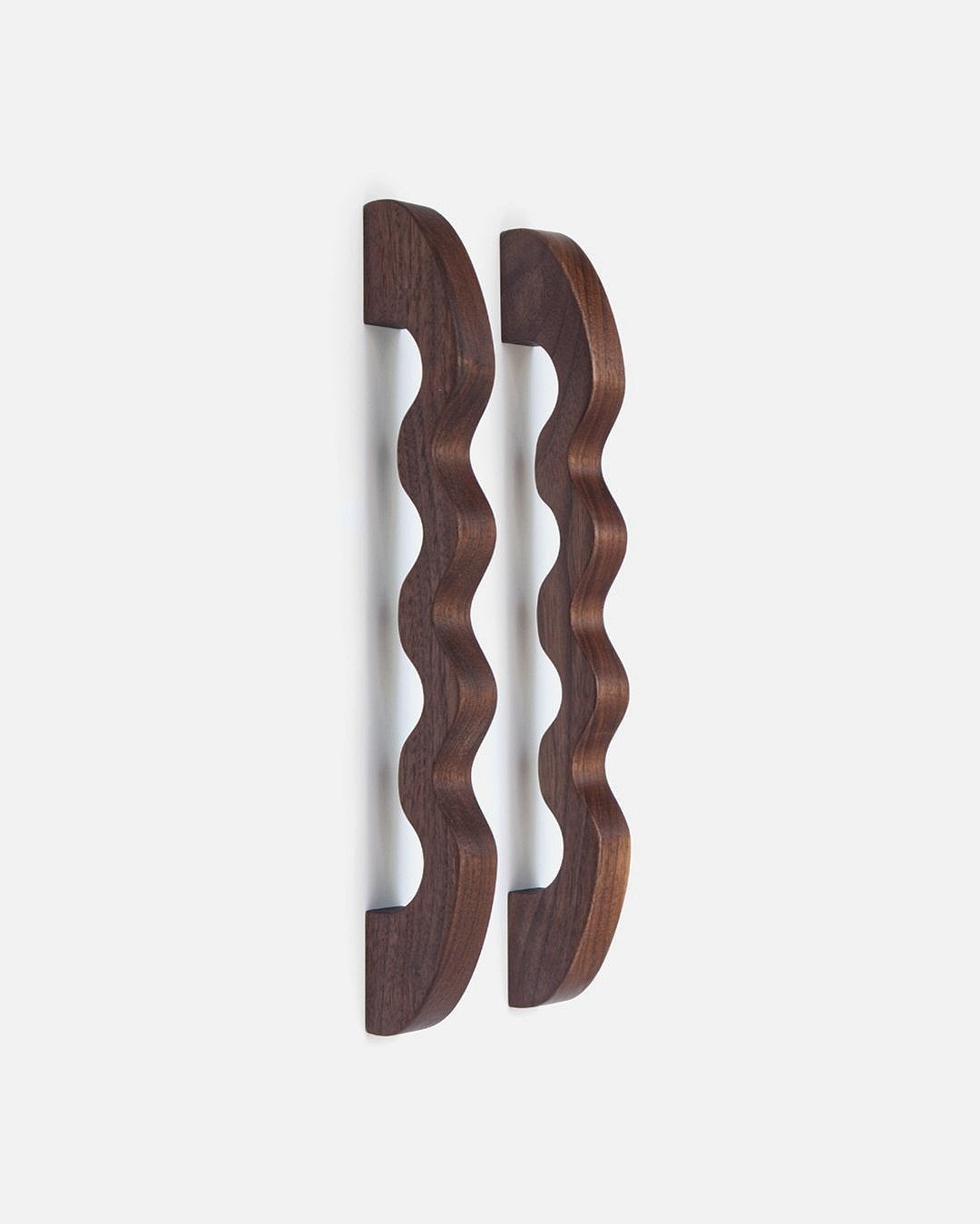 sculptural wavy handles and drawer pulls in walnut wood