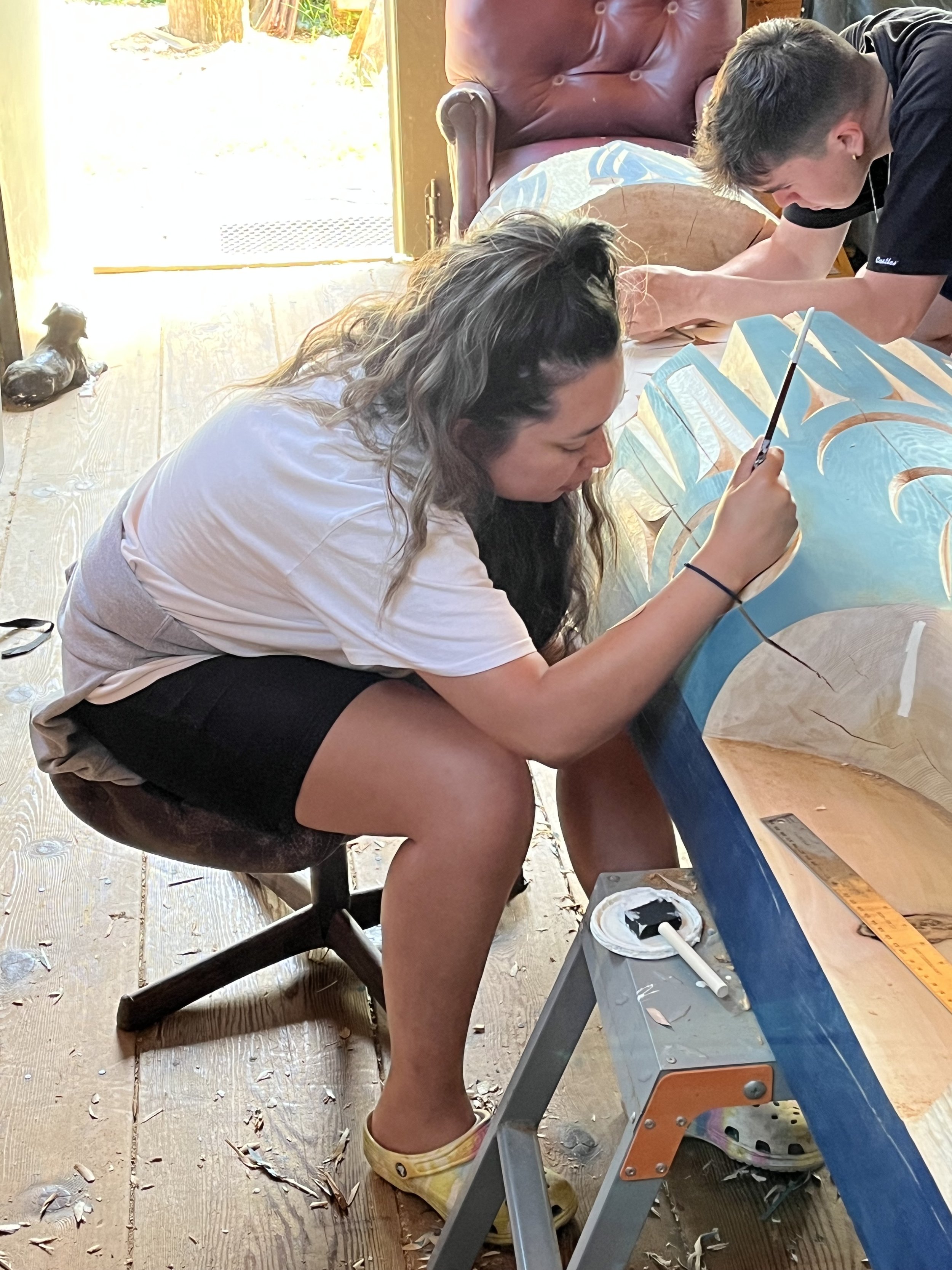 Addie Elliot painting the welcome pole