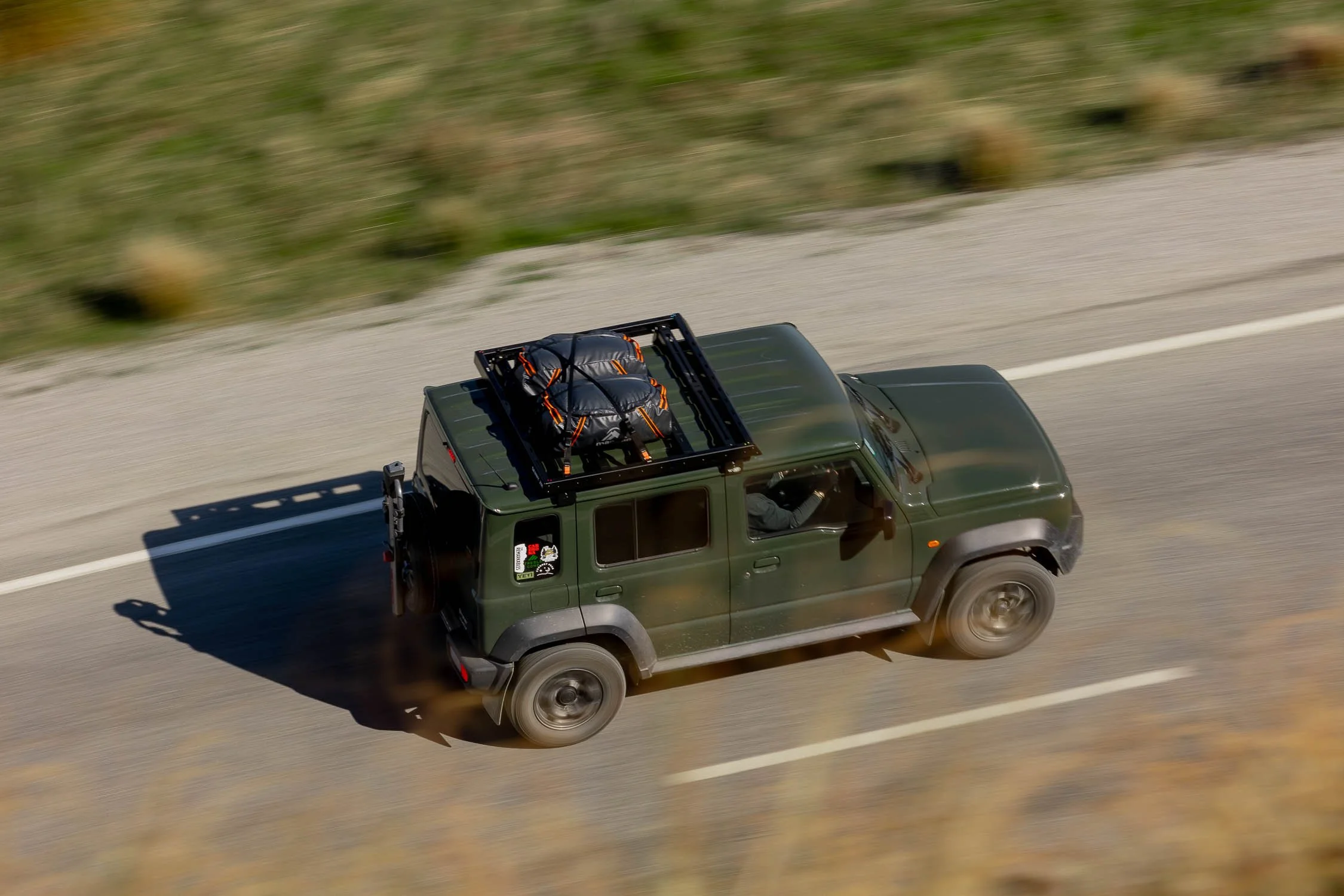 Jimny XL on mountain road with cargo on roof