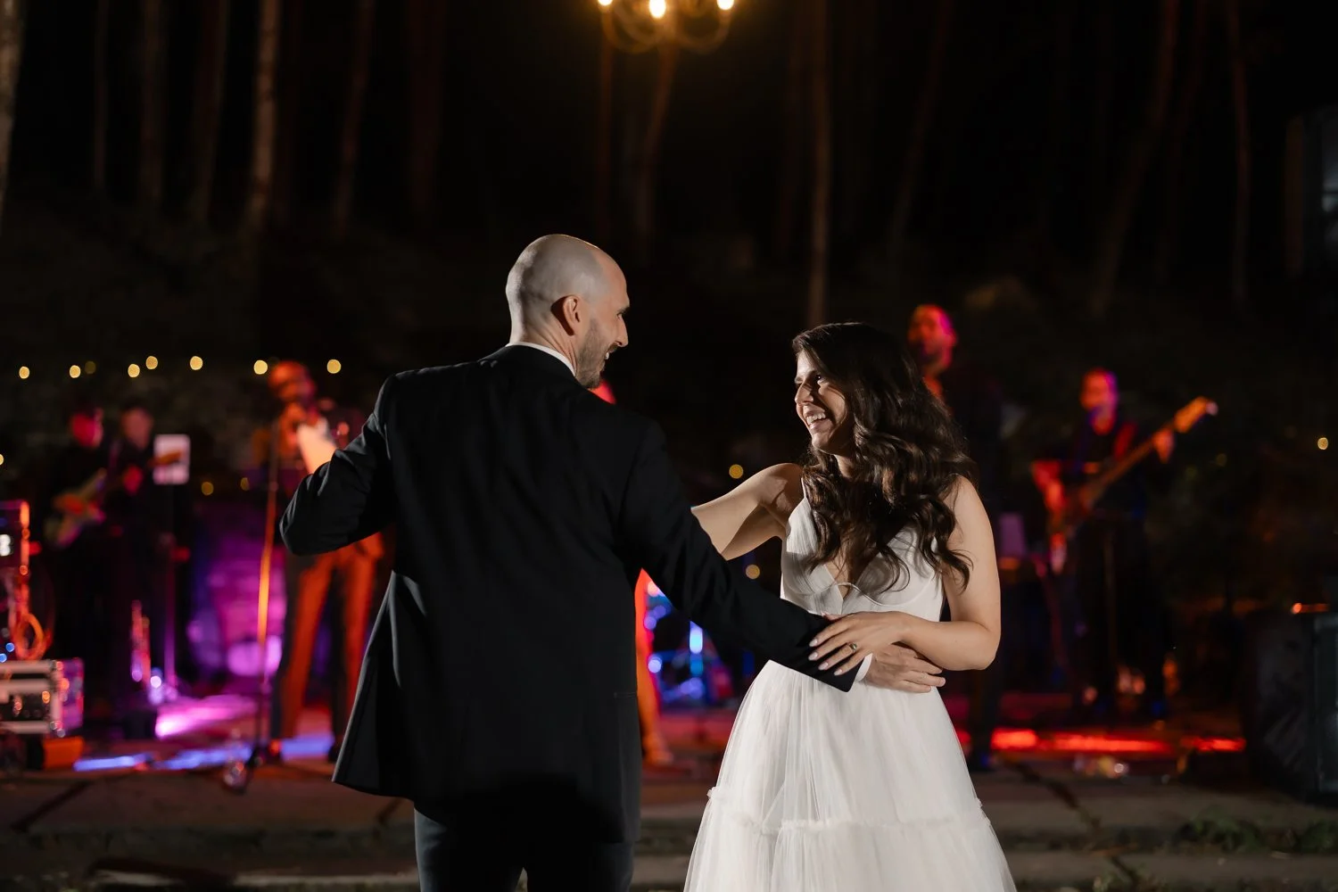Couple shares first dance on outdoor dance floor during wedding reception in Catskills.