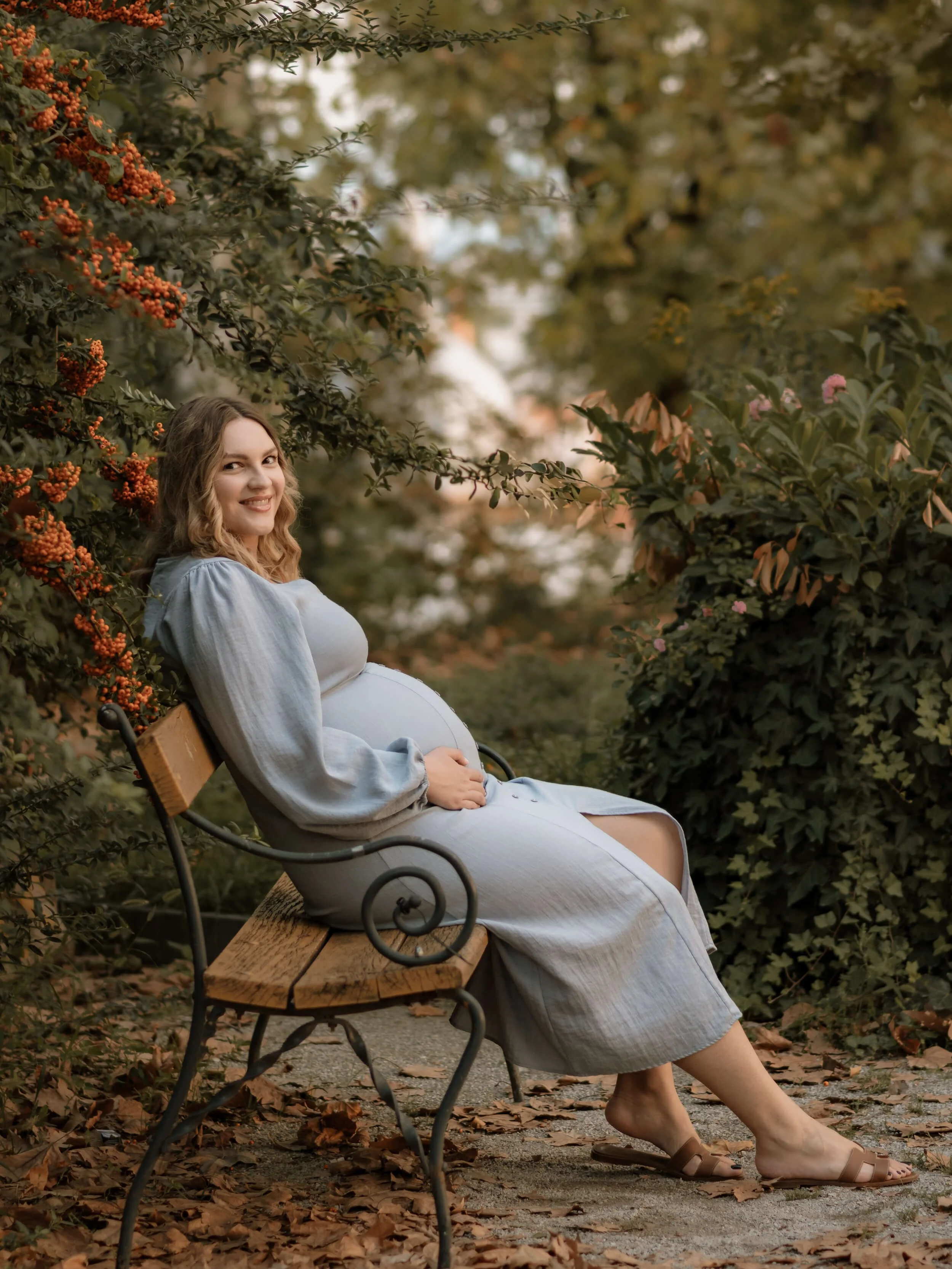 Trudnica u plavoj haljini sjedi na klupi