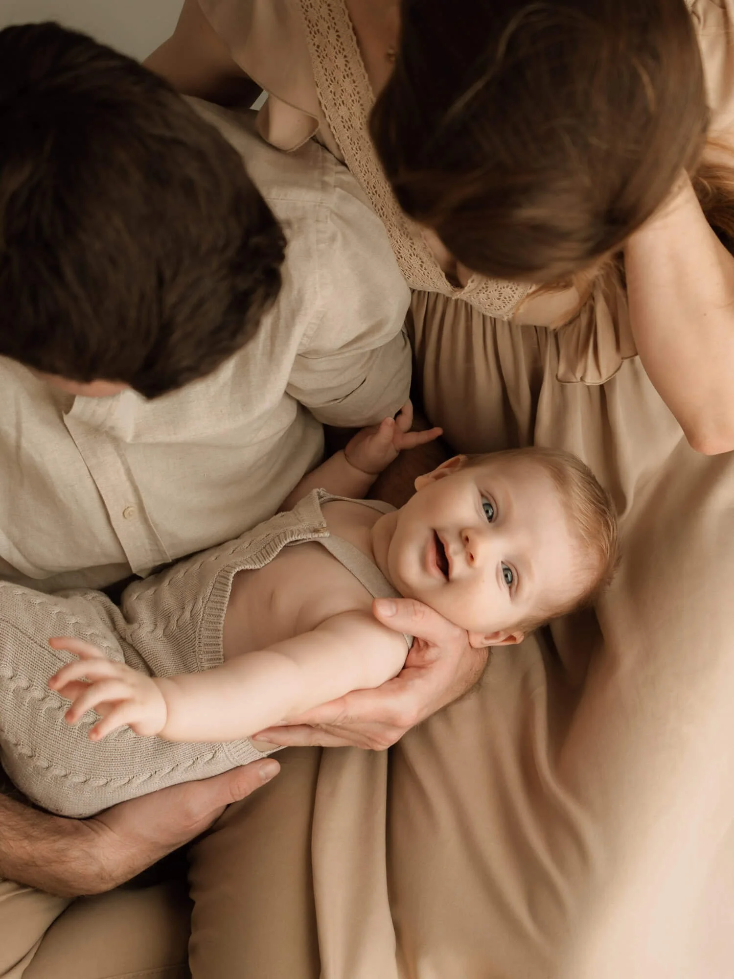 Beba u naručju roditelja u njihovom domu