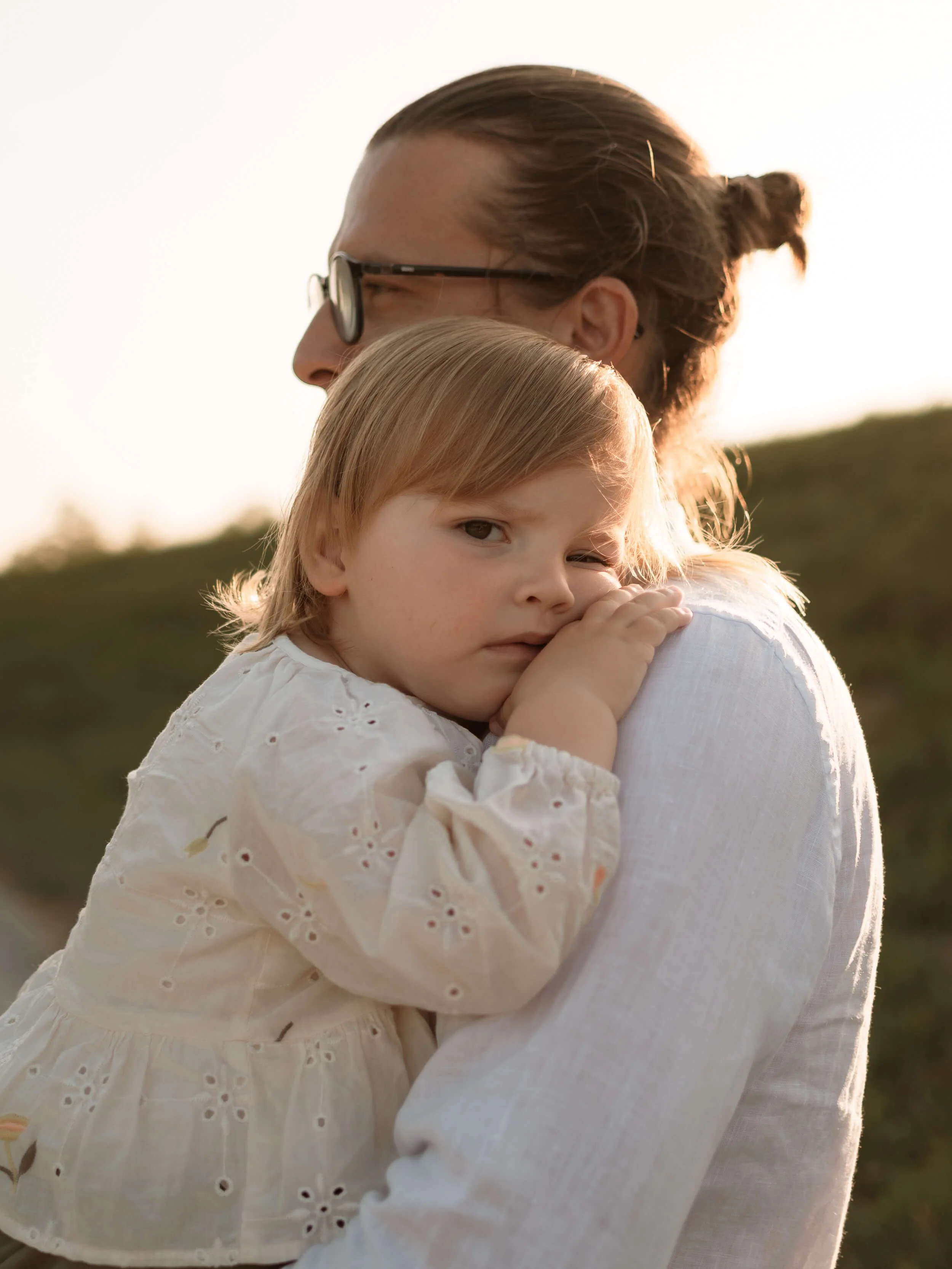Slikanje djece u prirodi, djevojčica na tatinom ramenu gleda u kameru