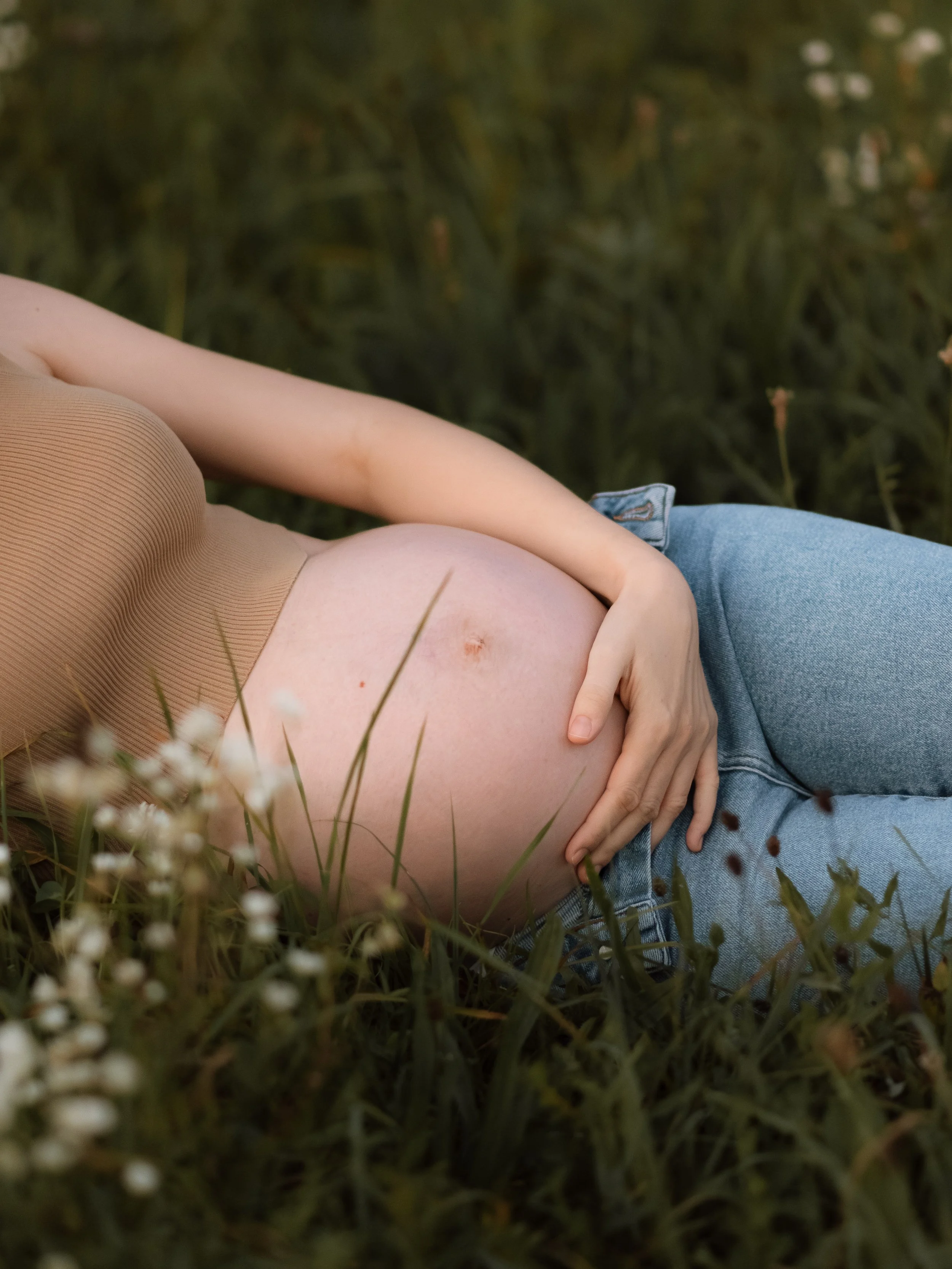 Trudnički trbuh slikan u travi