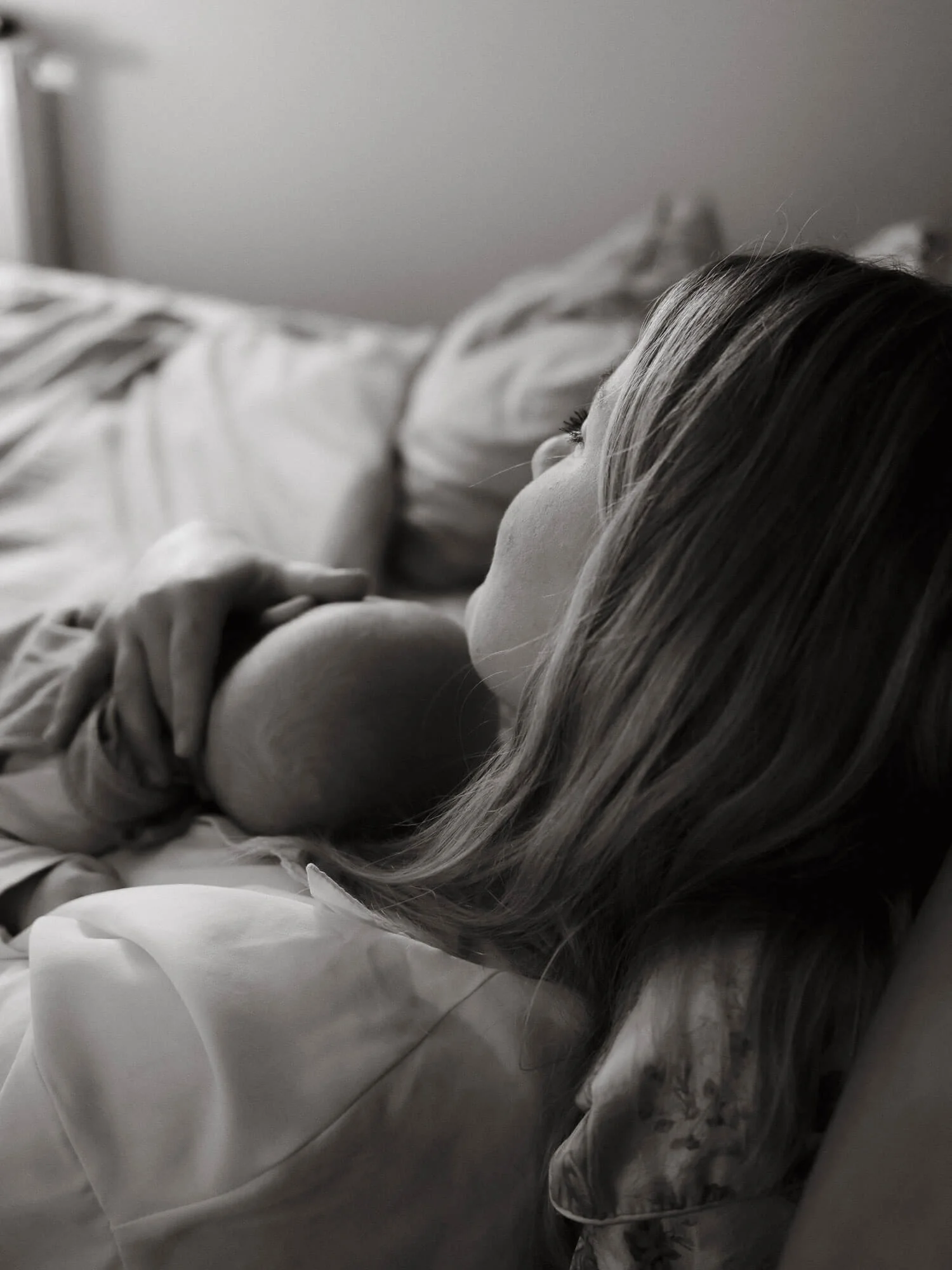 Mama i beba u naručju leže na krevetu