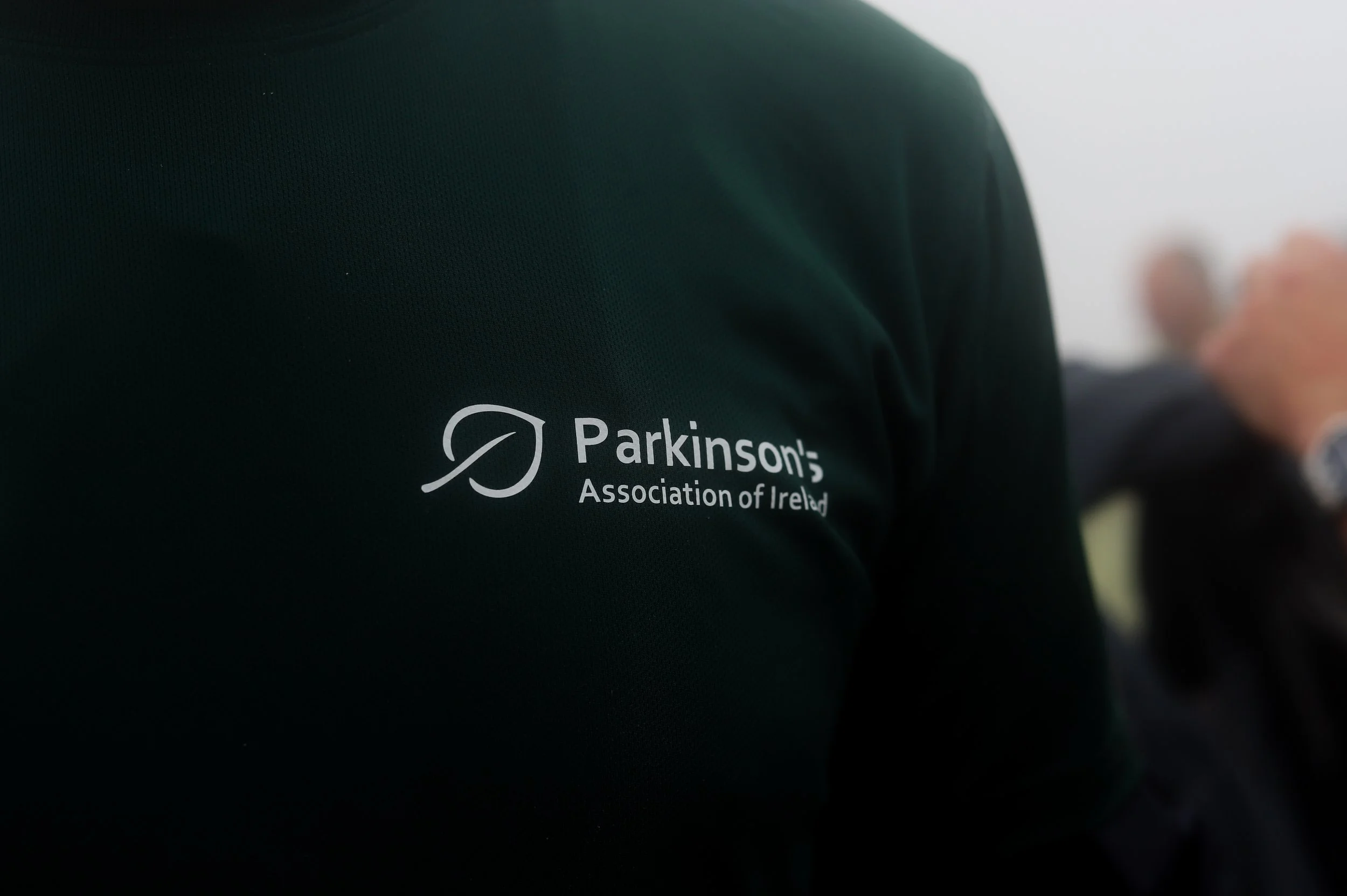 Close-up of a black shirt with a logo and text for the Parkinson's Association of Ireland.