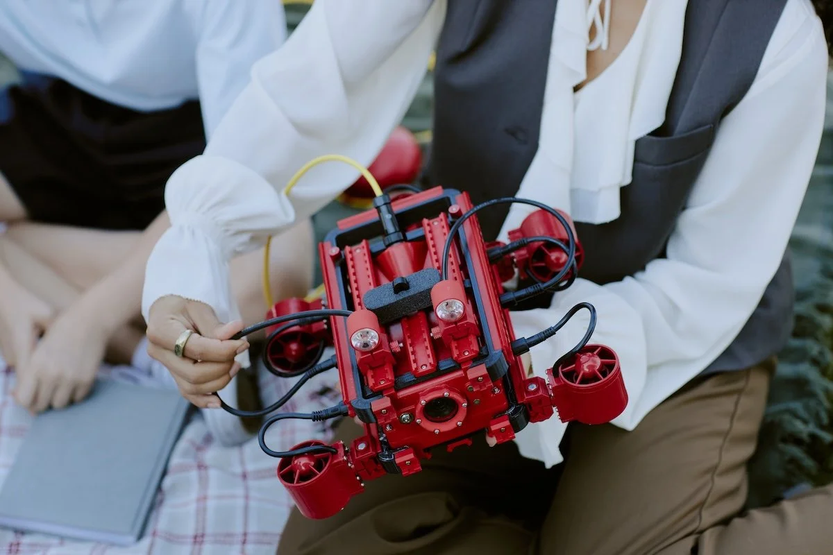 Researcher holding underwater drone used for student-led marine research project