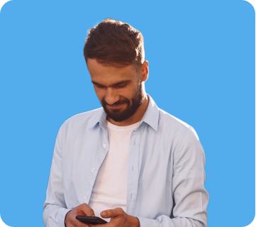 A man with a beard and short hair looking down at his phone, smiling, against a blue background.