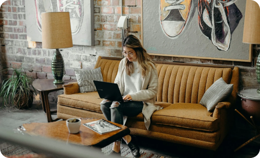 Woman sitting on sofa with a laptop