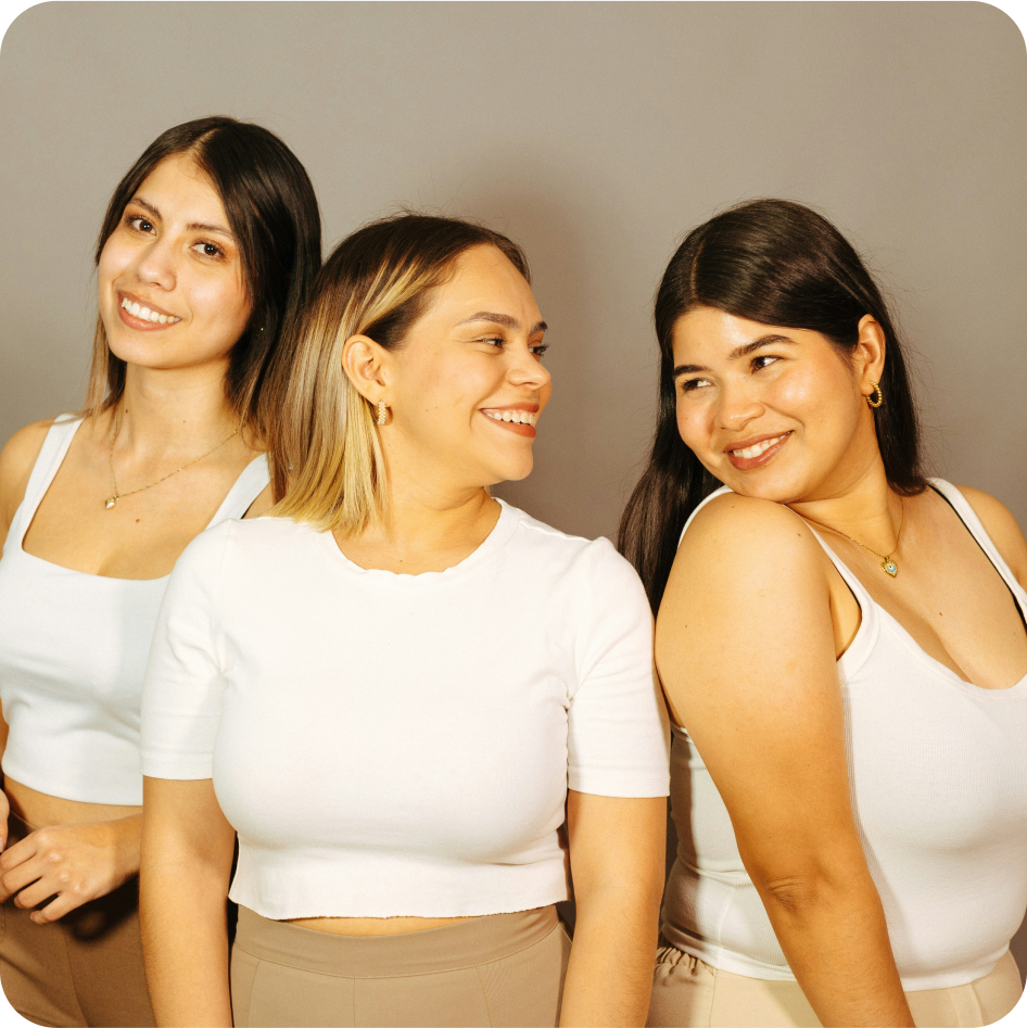 Three women in basic apparel smiling