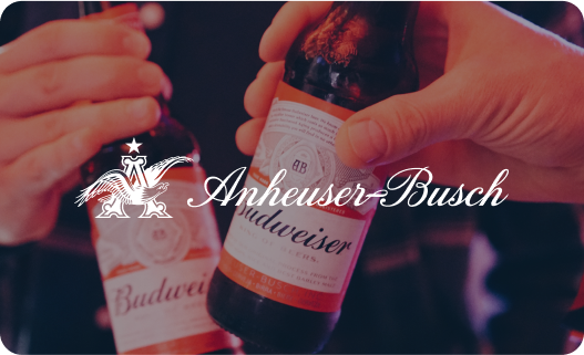 Two people clinking Budweiser beer bottles in a toast.