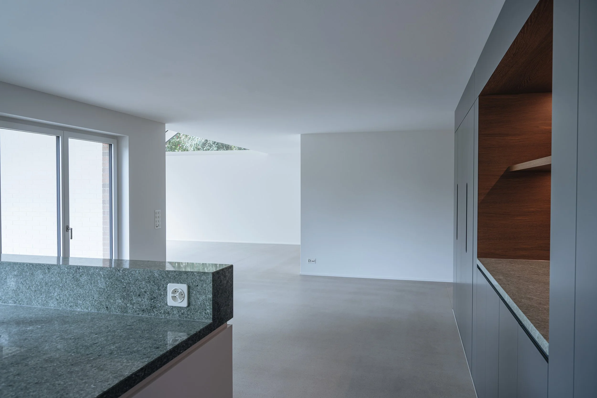 Anbau Wohnraum, Cheminée mit rotem Plattenschild, grosszügiger Essbereich, fliessender Boden, Schrankfront mit Nische