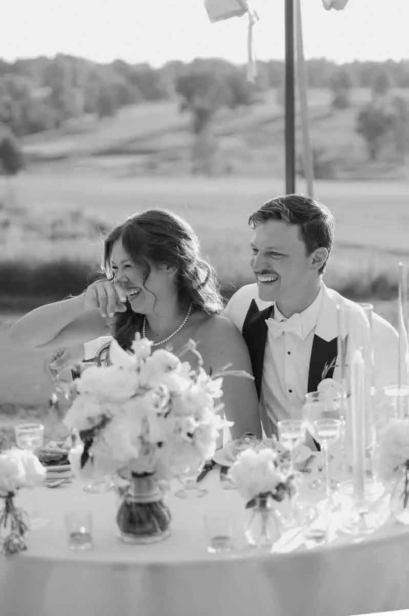 Bride and groom laughing together during speeches at a Scranton Country Club wedding