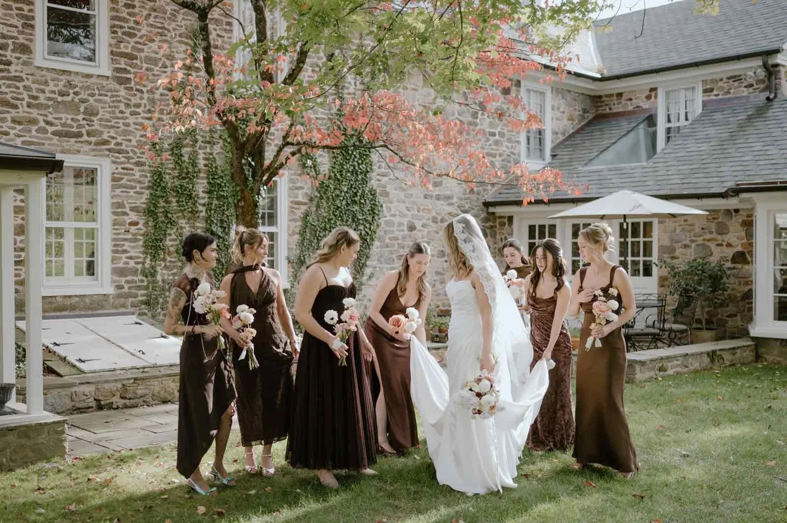 Bridesmaids helping bride with dress at Fox Briar Farm