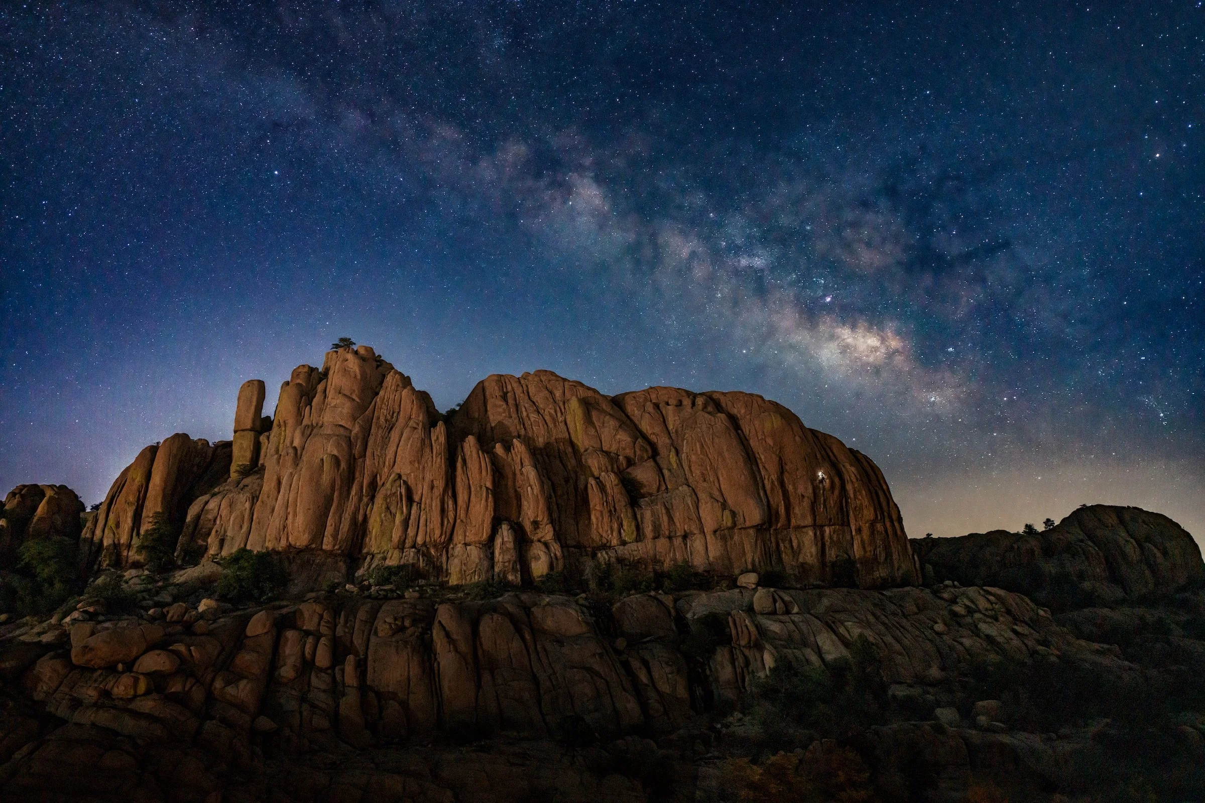 NIGHT CLIMBER IN THE DELLS (Published in Alpinist Magazine Issue 87) – Erin Connery climbs The High Rappel Wall under The Milky Way in Prescott, Arizona. I positioned myself with a tripod on a narrow ledge on the opposite side of the canyon. Erin and