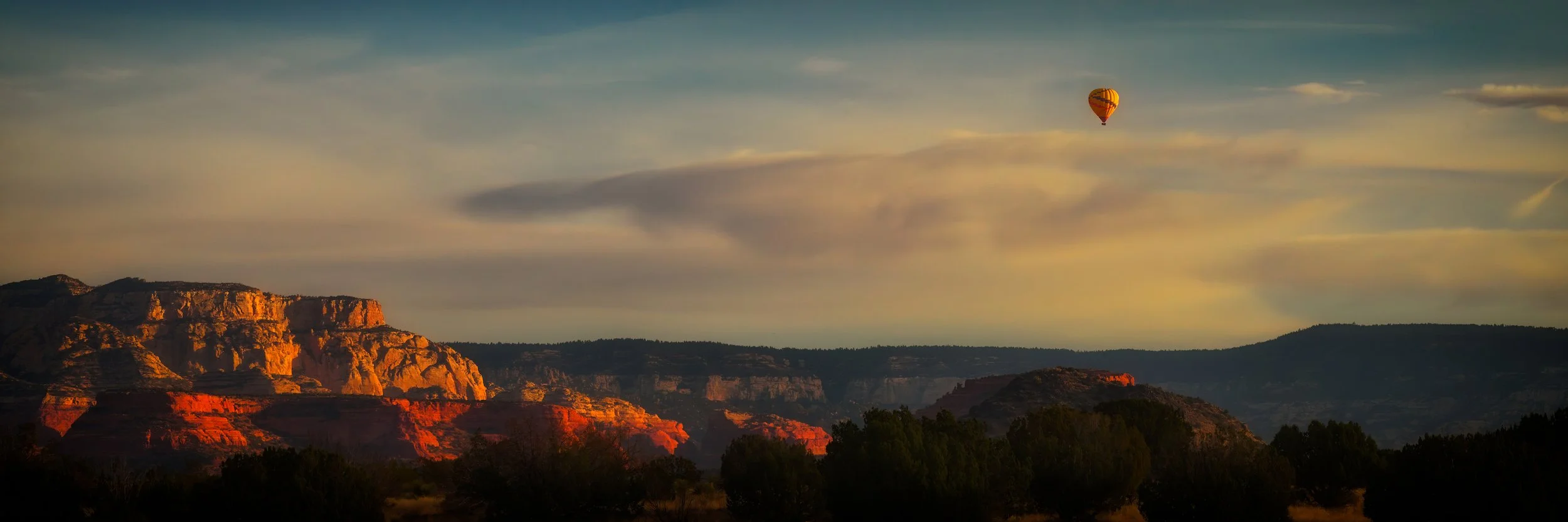 EARLY RISER – While driving into Sedona at sunrise, a single hot air balloon floated above the canyon rim. I jumped out of my vehicle, hiked to a nearby ridge and captured this perfect moment.