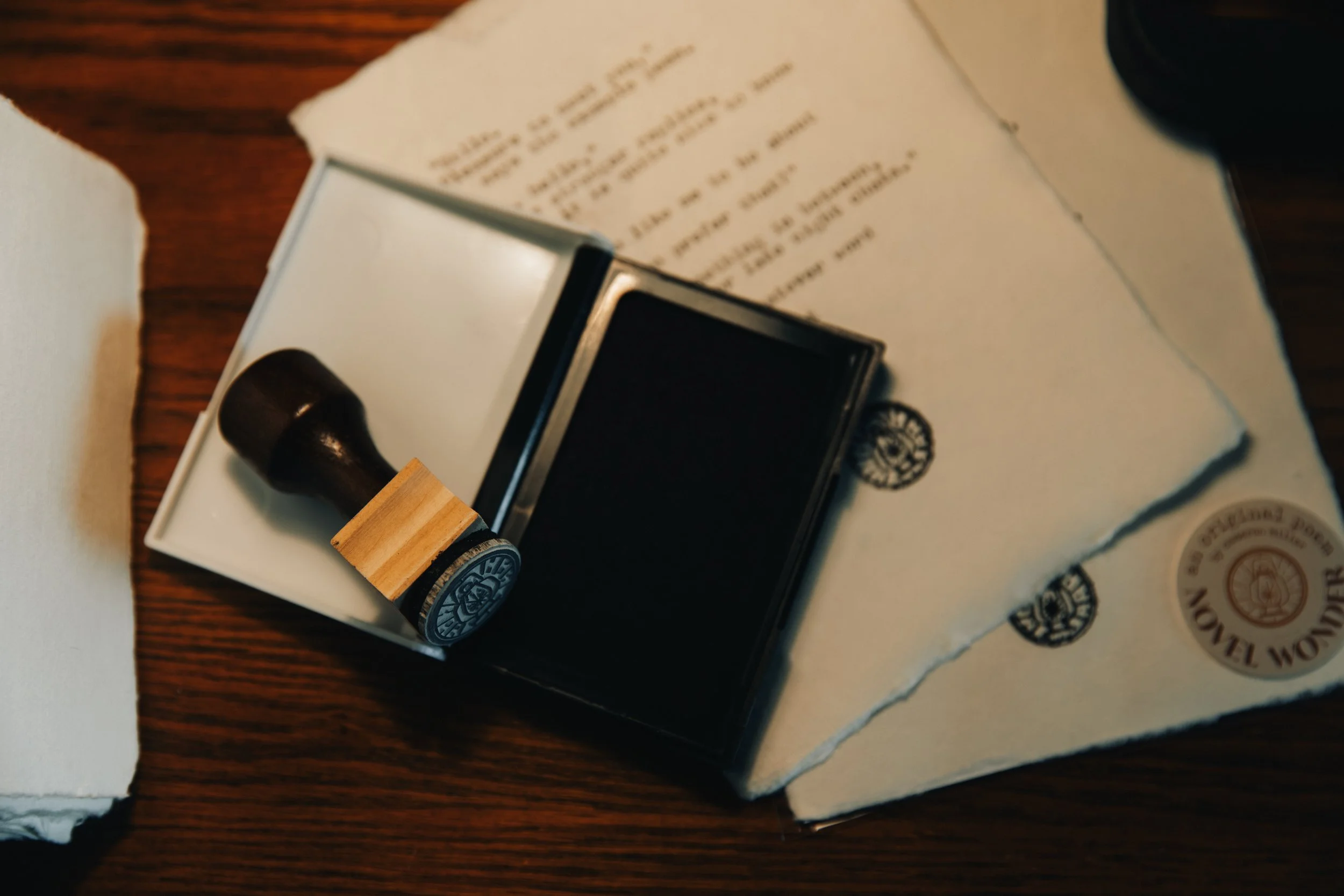 A lantern stamp is set upon two typewritten poems on 5x7 paper, one in a plastic sleeve.