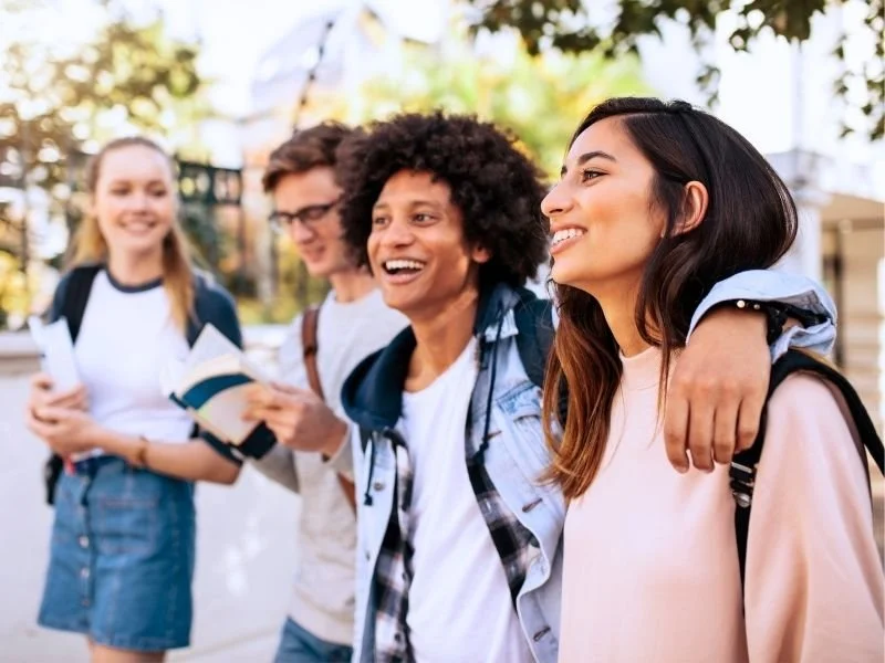 A group of young college students walking on campus